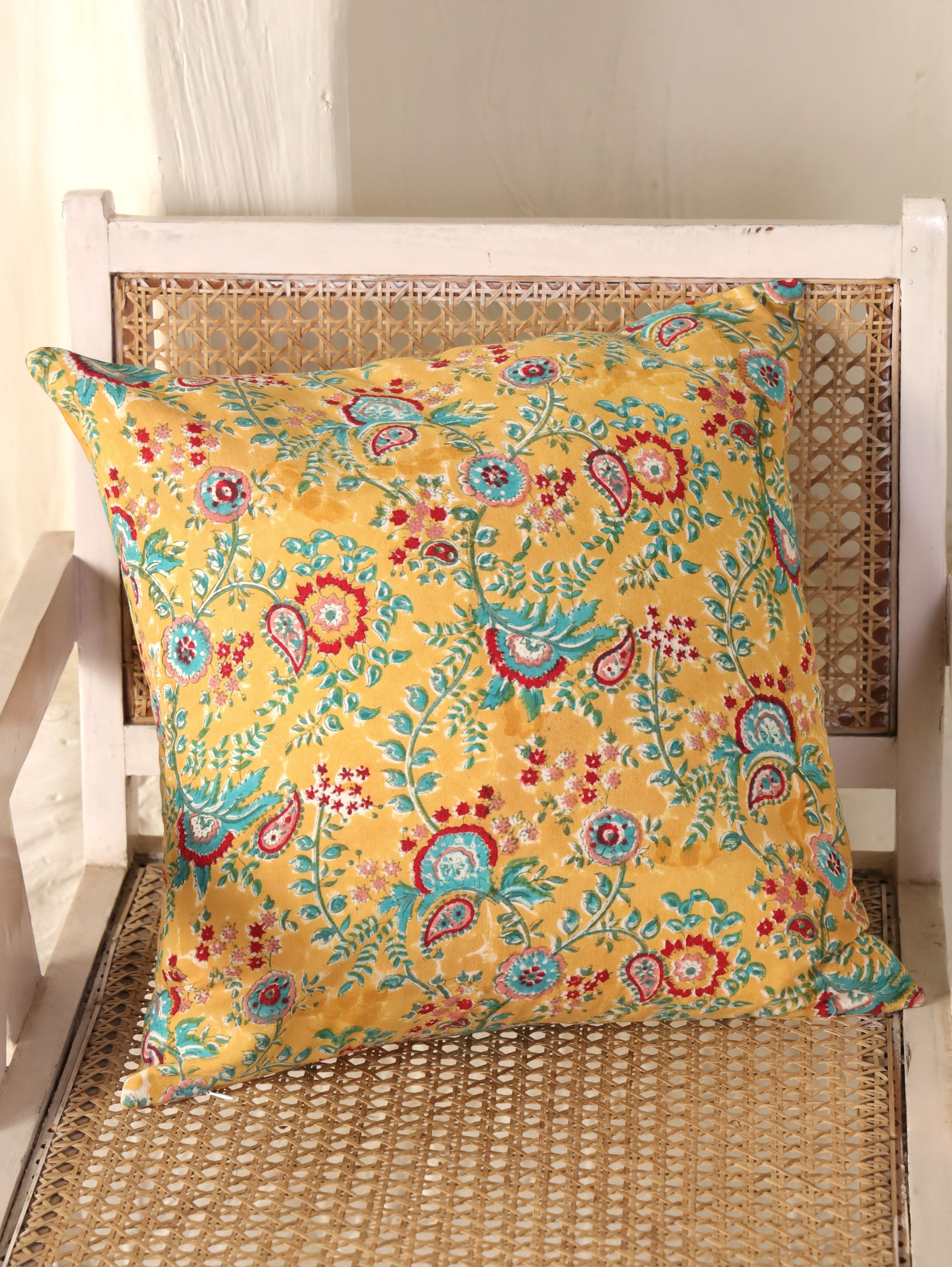 The Block & Bloom mustard cotton cushion cover featuring hand block printed teal and crimson paisley and floral motifs.