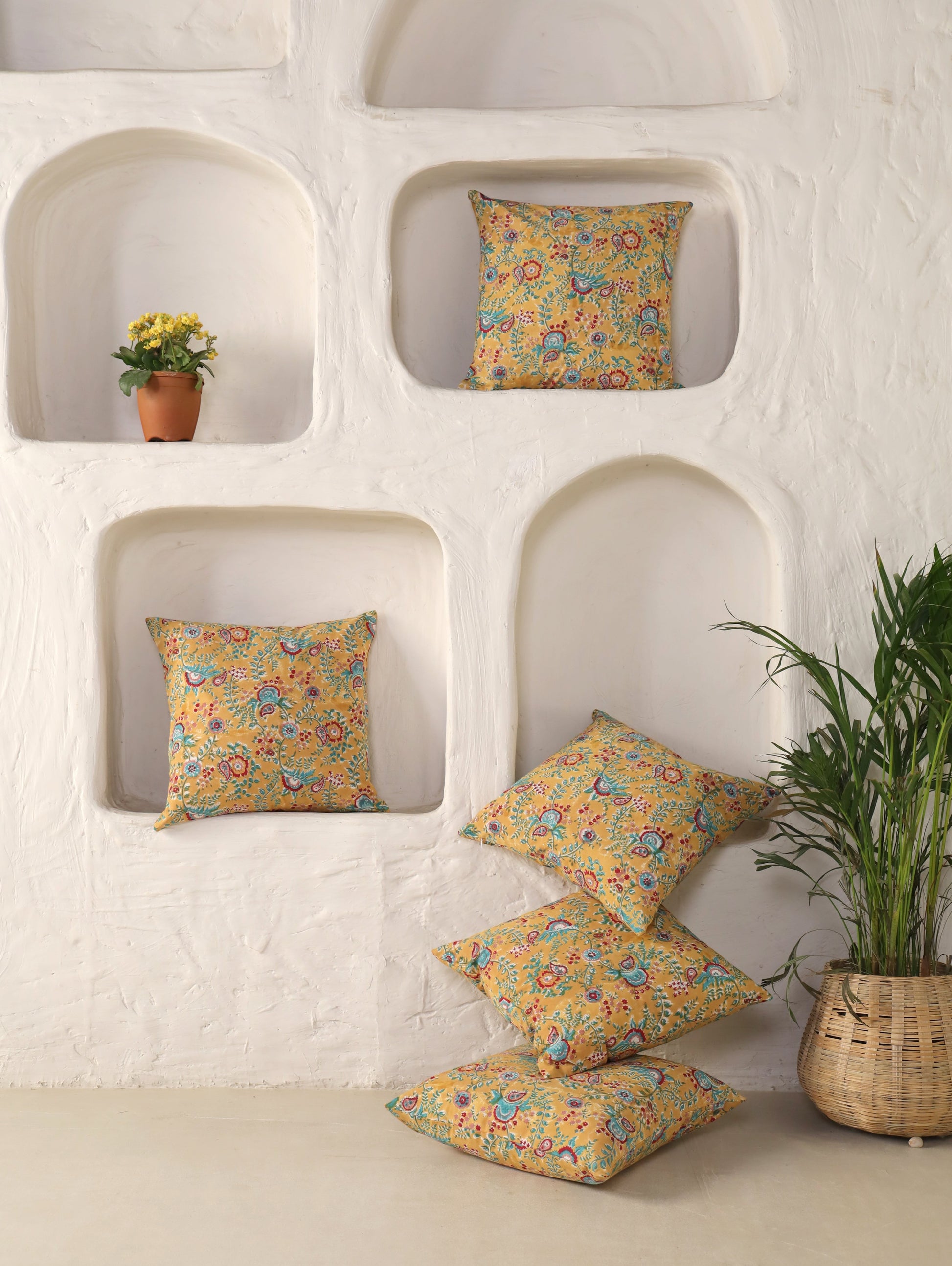 The Block & Bloom mustard cotton cushion covers with teal and crimson paisley prints in a white arched wall display.