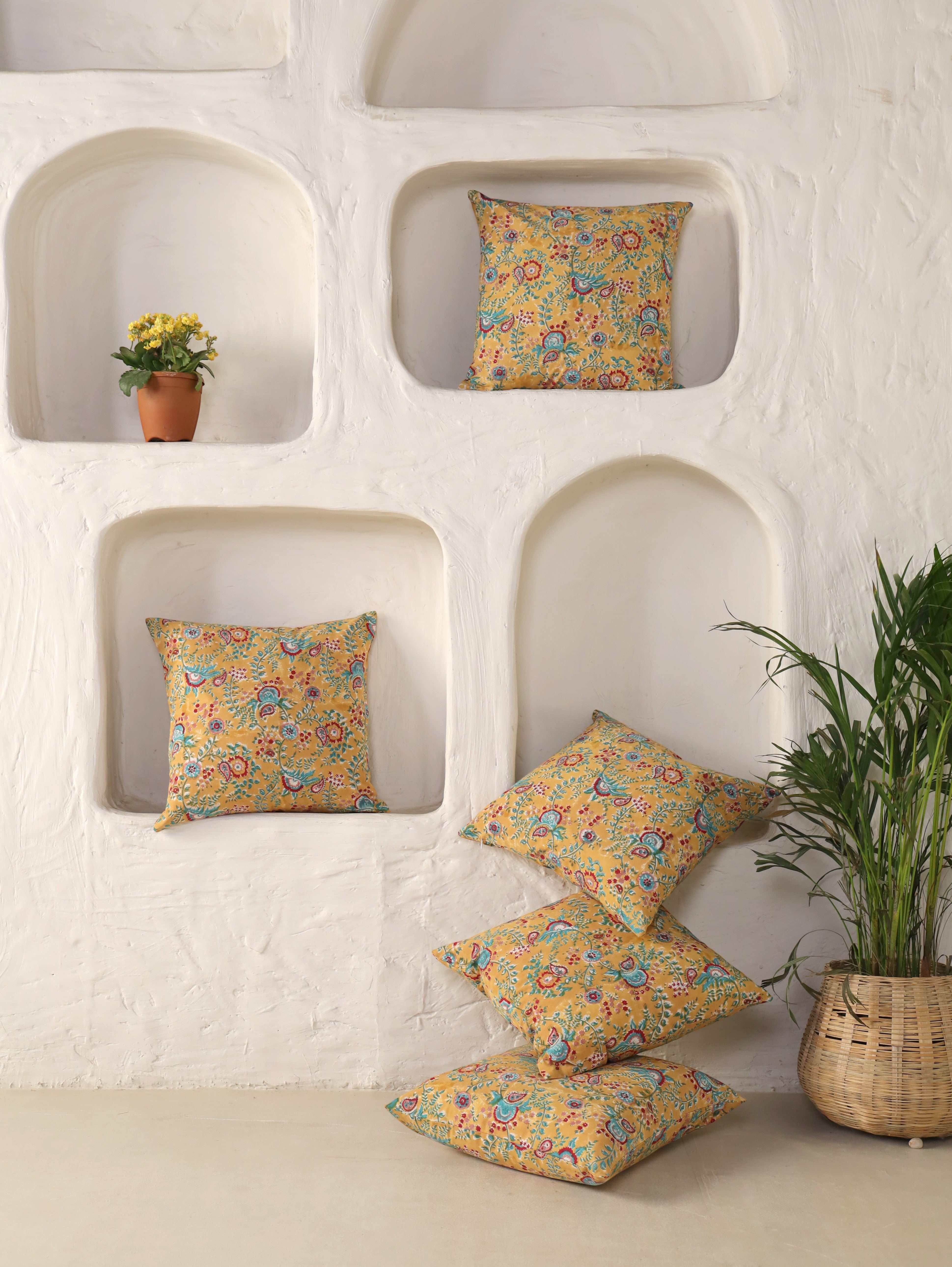 The Block & Bloom mustard cotton cushion covers with teal and crimson paisley prints in a white arched wall display.