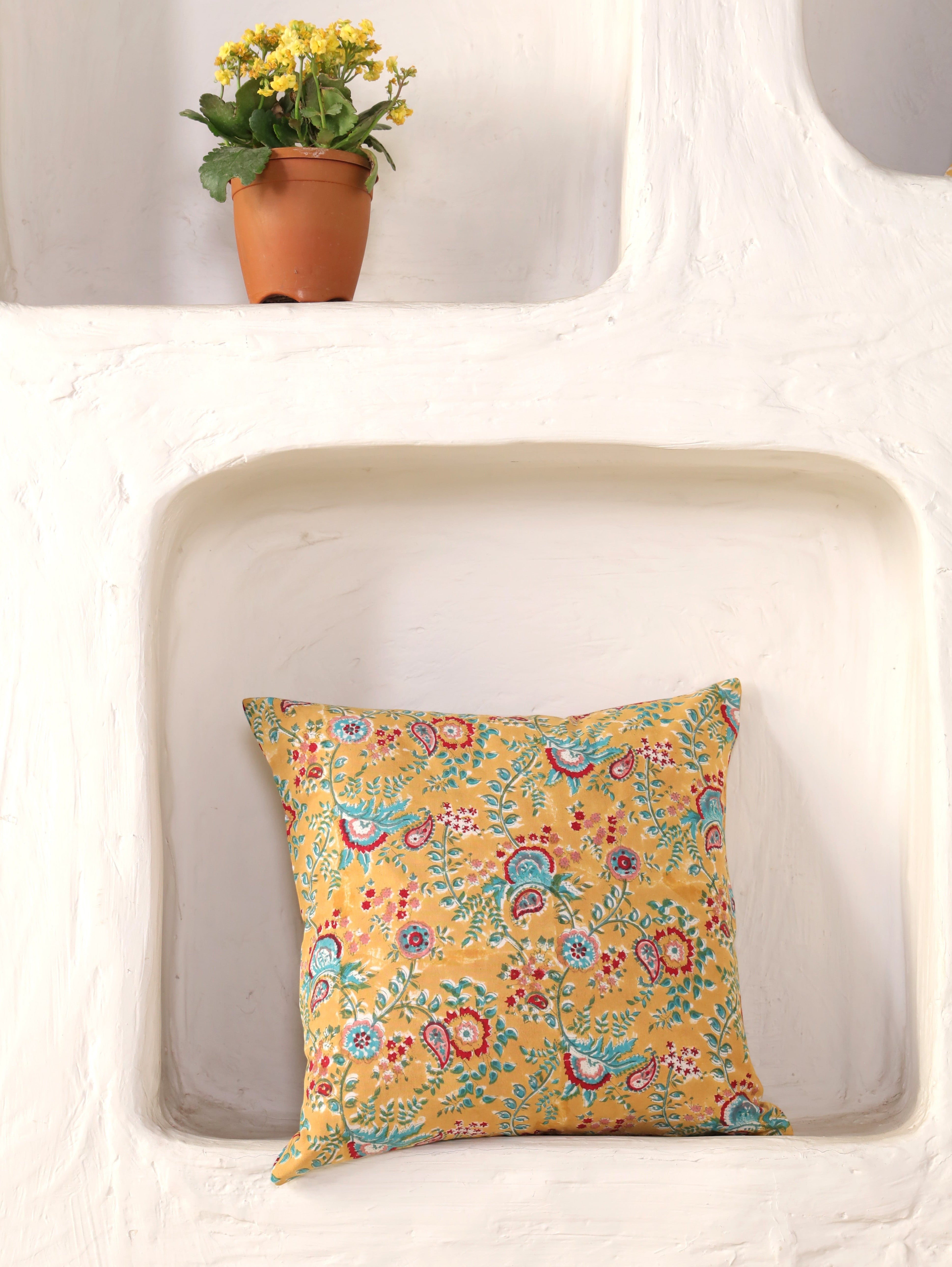 The Block & Bloom mustard cotton cushion cover featuring hand block printed teal and crimson paisley floral patterns.