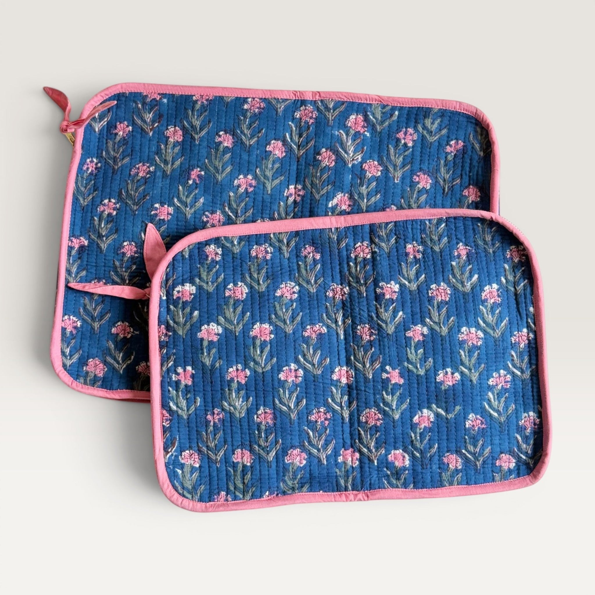 The Block & Bloom navy blue quilted laptop sleeve with pink carnation floral print and pink fabric trim.