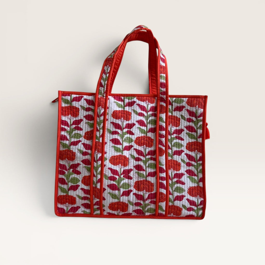 The Block & Bloom orange carnation quilted tote bag with floral block print on white cotton with red trim.
