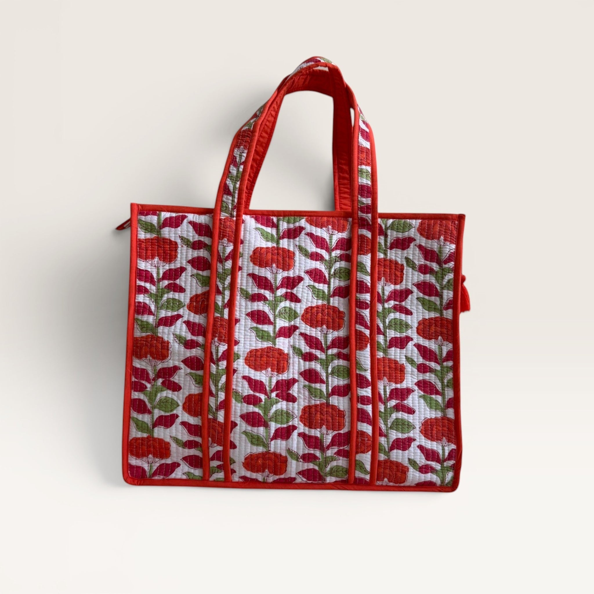 The Block & Bloom orange carnation quilted tote bag with floral block print on white cotton with red trim.