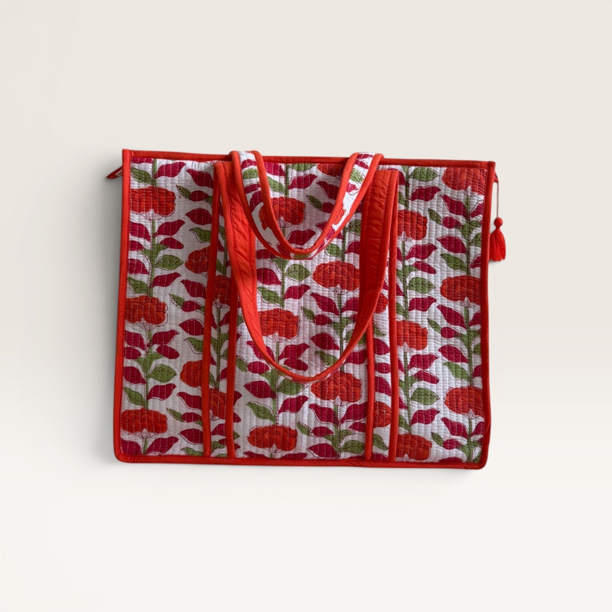 The Block & Bloom quilted tote bag featuring an orange carnation floral print on white cotton with red trim.