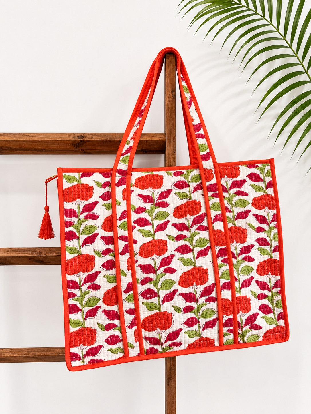The Block & Bloom orange carnation quilted tote bag with floral block print on white cotton with red trim.
