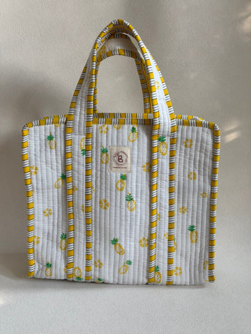 The Block & Bloom quilted mini tote in white with yellow and green pineapple print and striped trim.