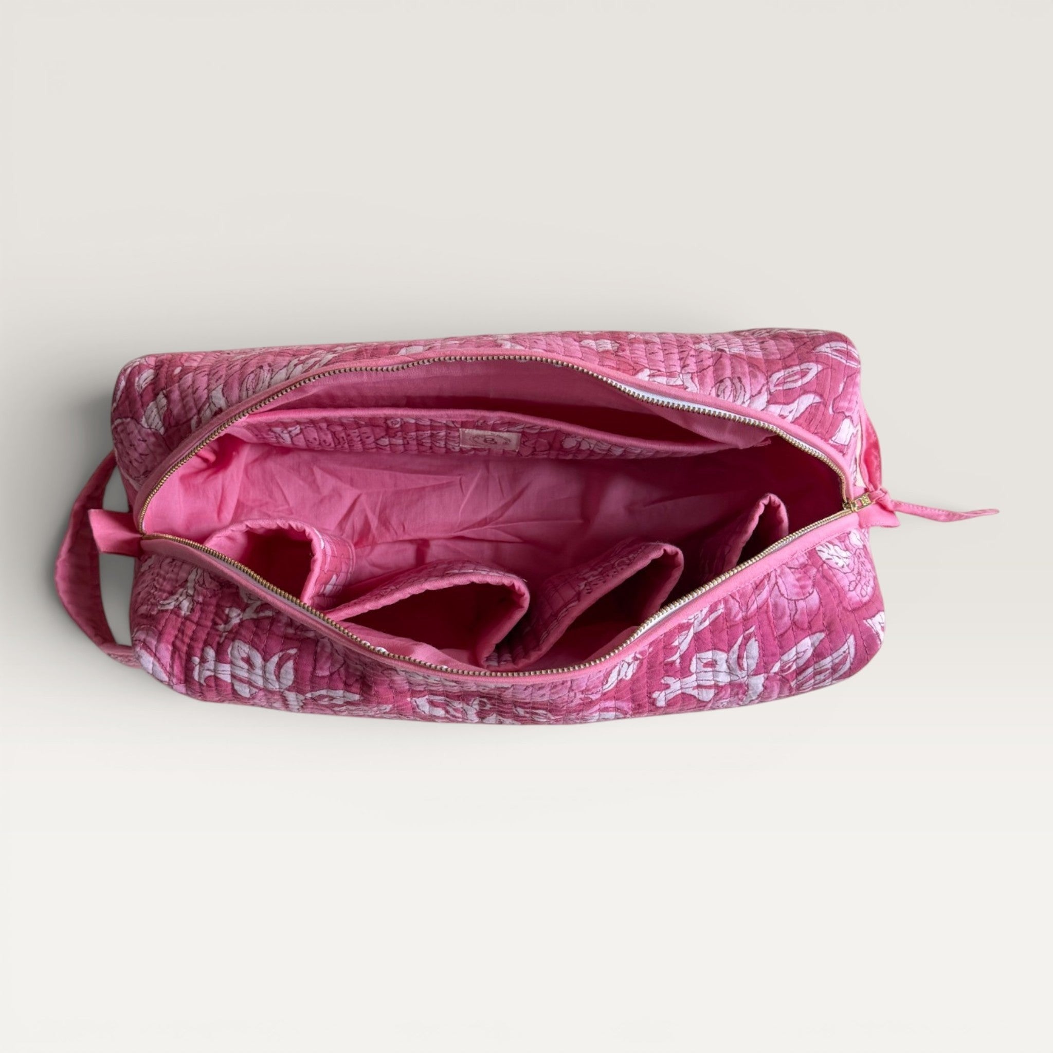 The Block & Bloom Rose Lily Bloom hair tool organizer bag with a quilted pink floral exterior and interior pockets.