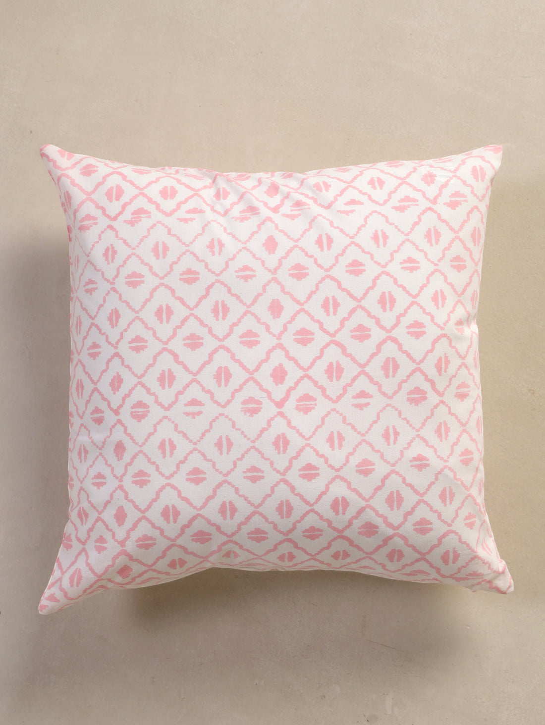 The Block & Bloom pink and ivory cotton cushion cover featuring a hand-block printed geometric diamond lattice pattern.