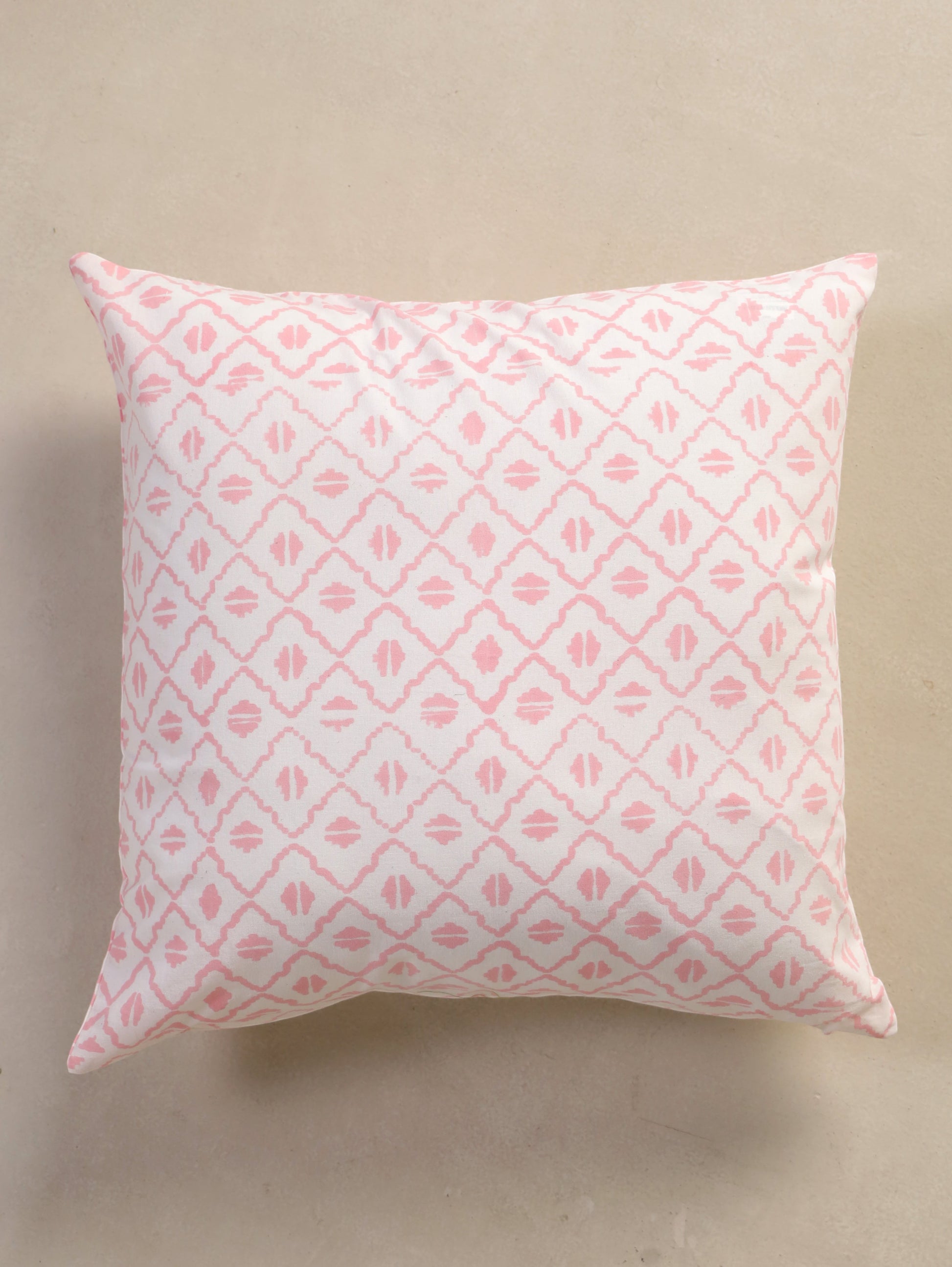 The Block & Bloom pink and ivory cotton cushion cover featuring a hand-block printed geometric diamond lattice pattern.