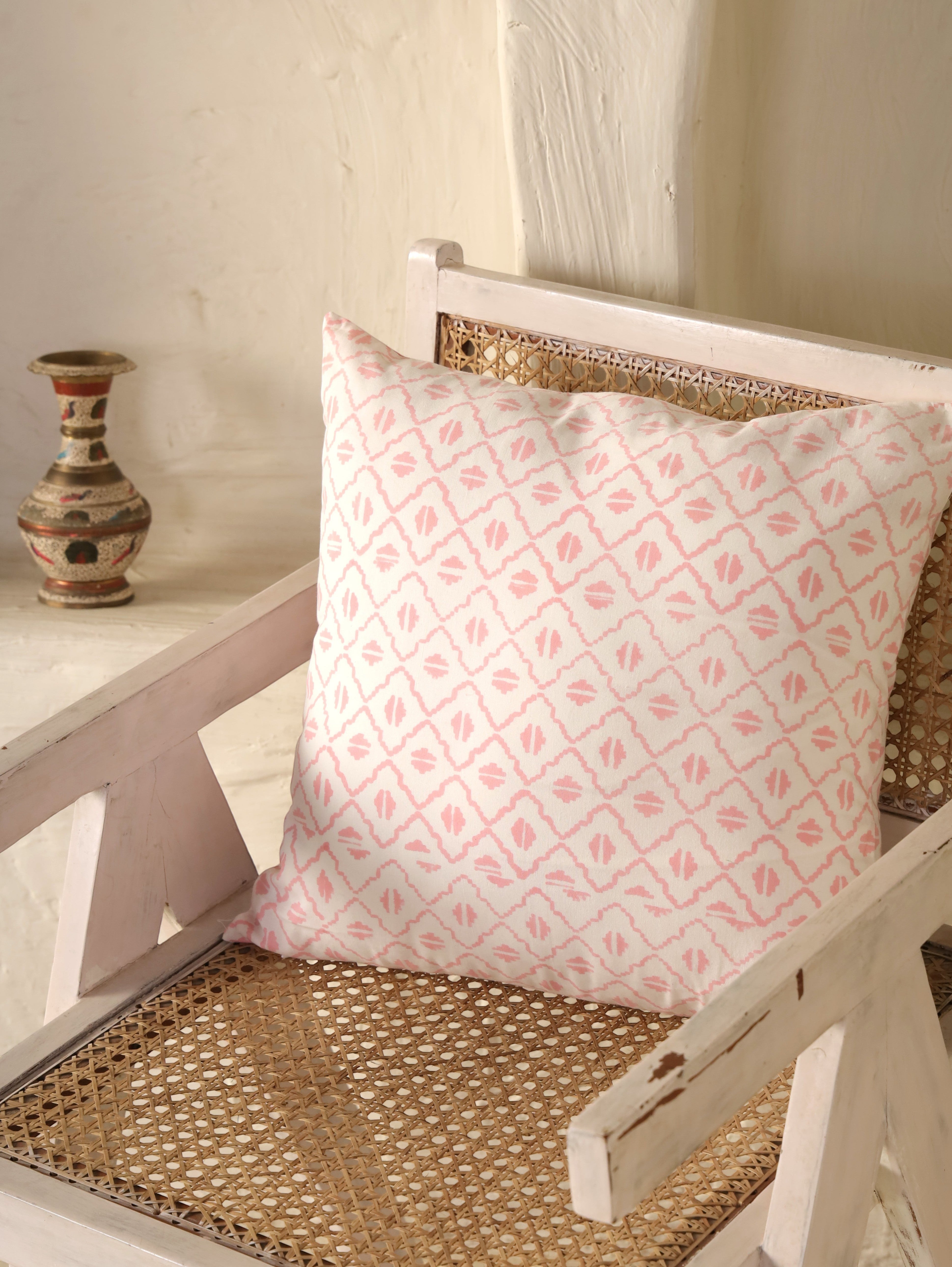 The Block & Bloom pink geometric cotton cushion cover with a hand-blocked diamond lattice pattern on an ivory chair.