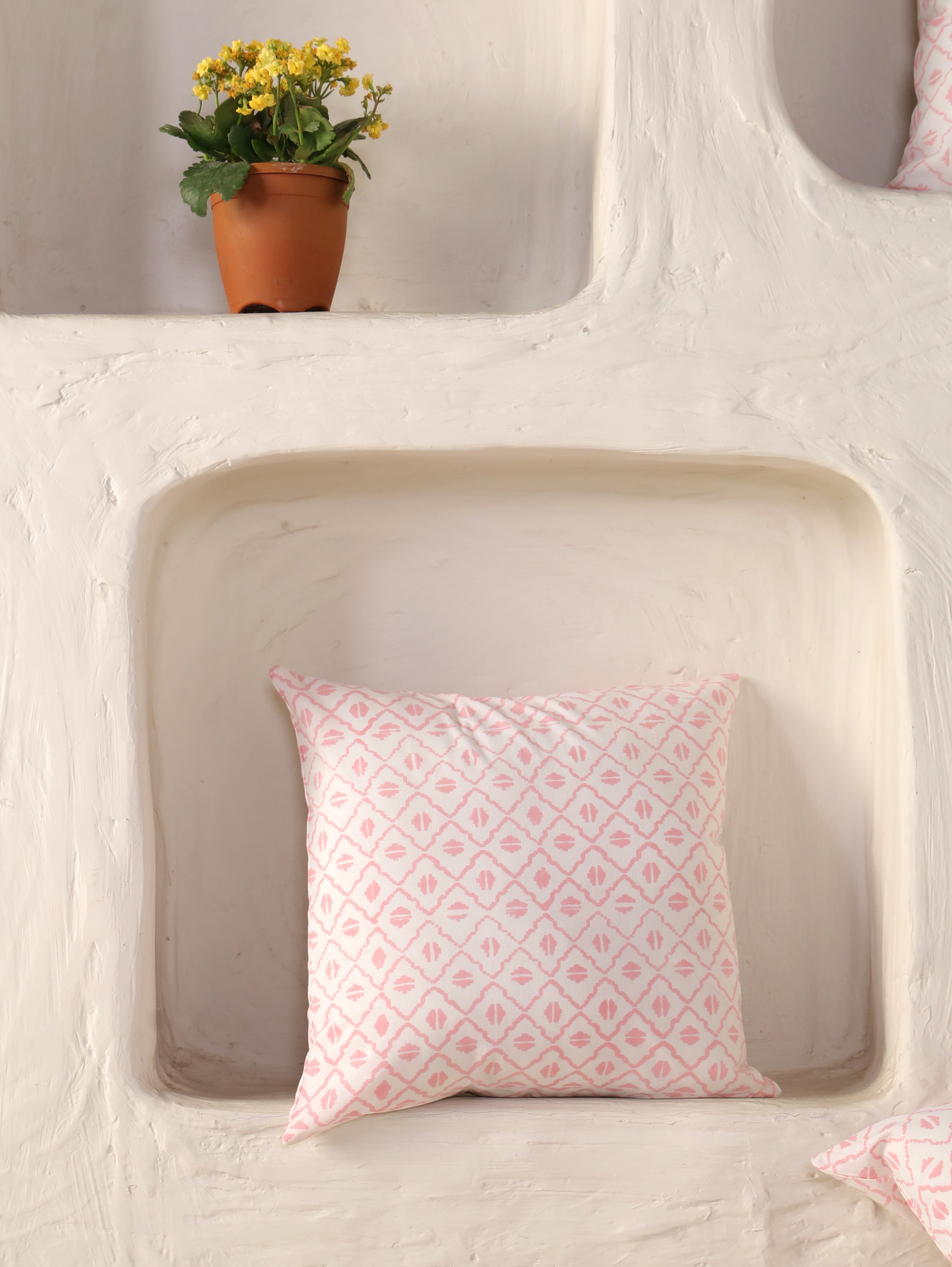 The Block & Bloom pink and ivory cotton cushion cover with a hand-blocked geometric diamond and seed motif pattern.