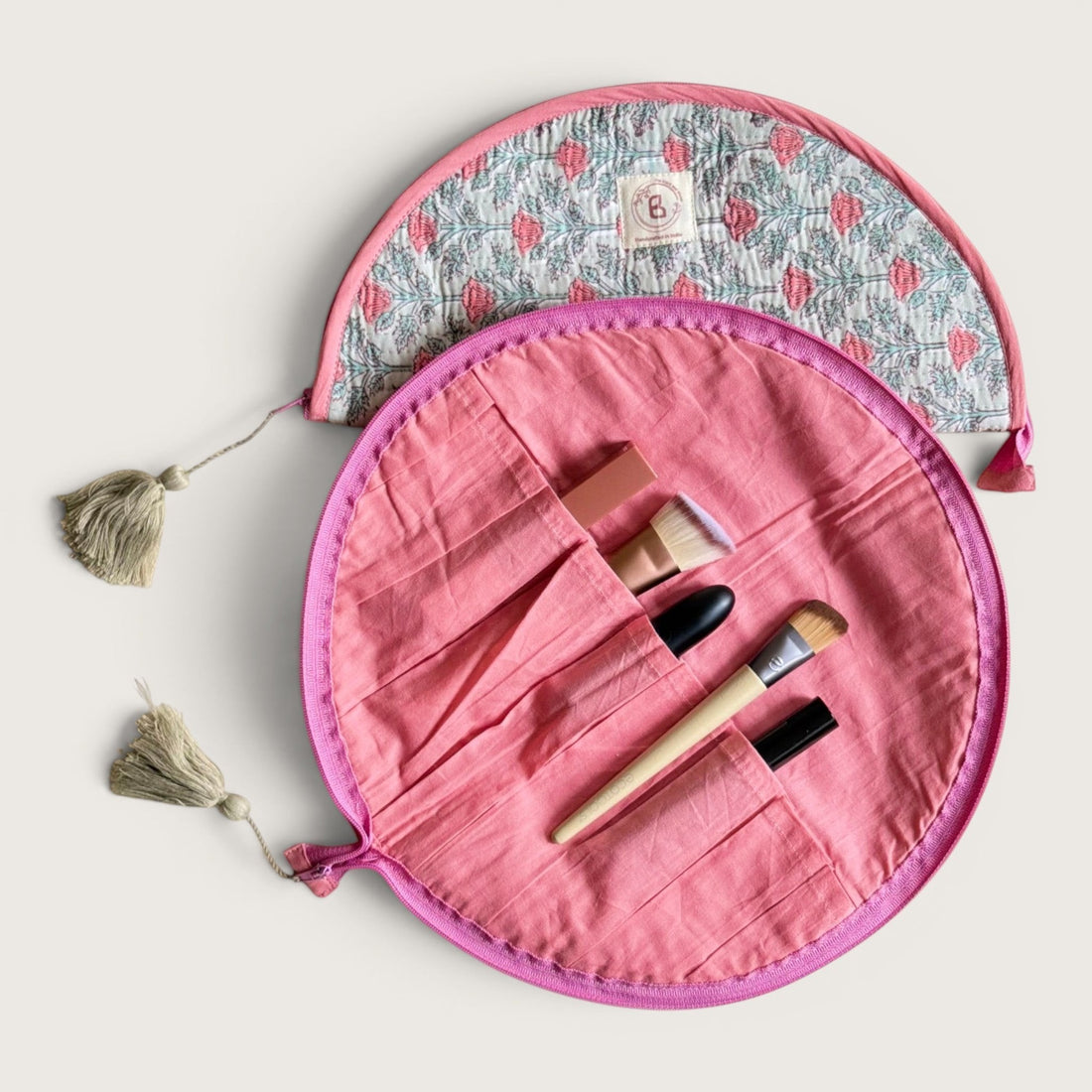 The Block & Bloom quilted cotton makeup brush pouch in sage green with pink floral vine print and tassel zipper pull.