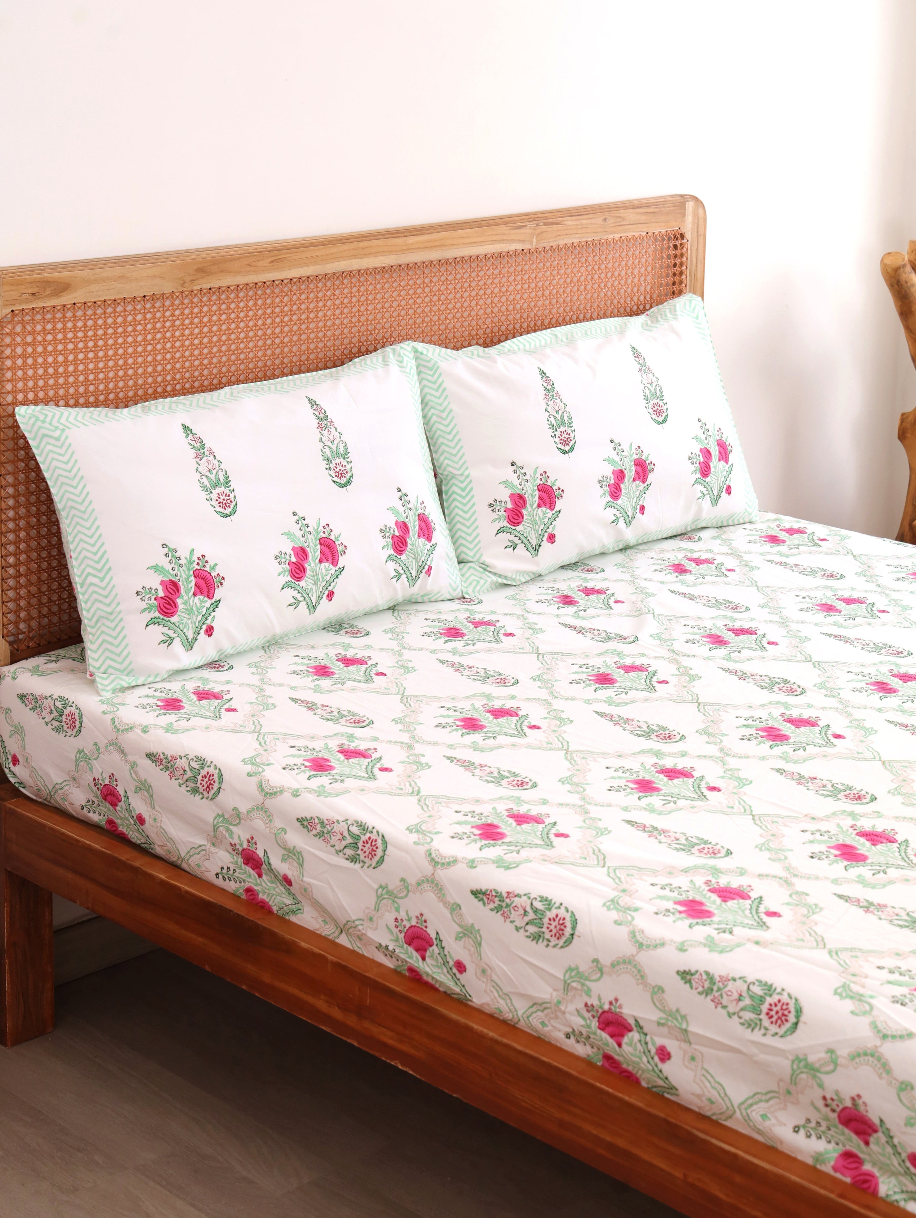 The Block & Bloom Pomegranate Meadow cotton fitted sheet and pillowcases with pink floral print on a white background.
