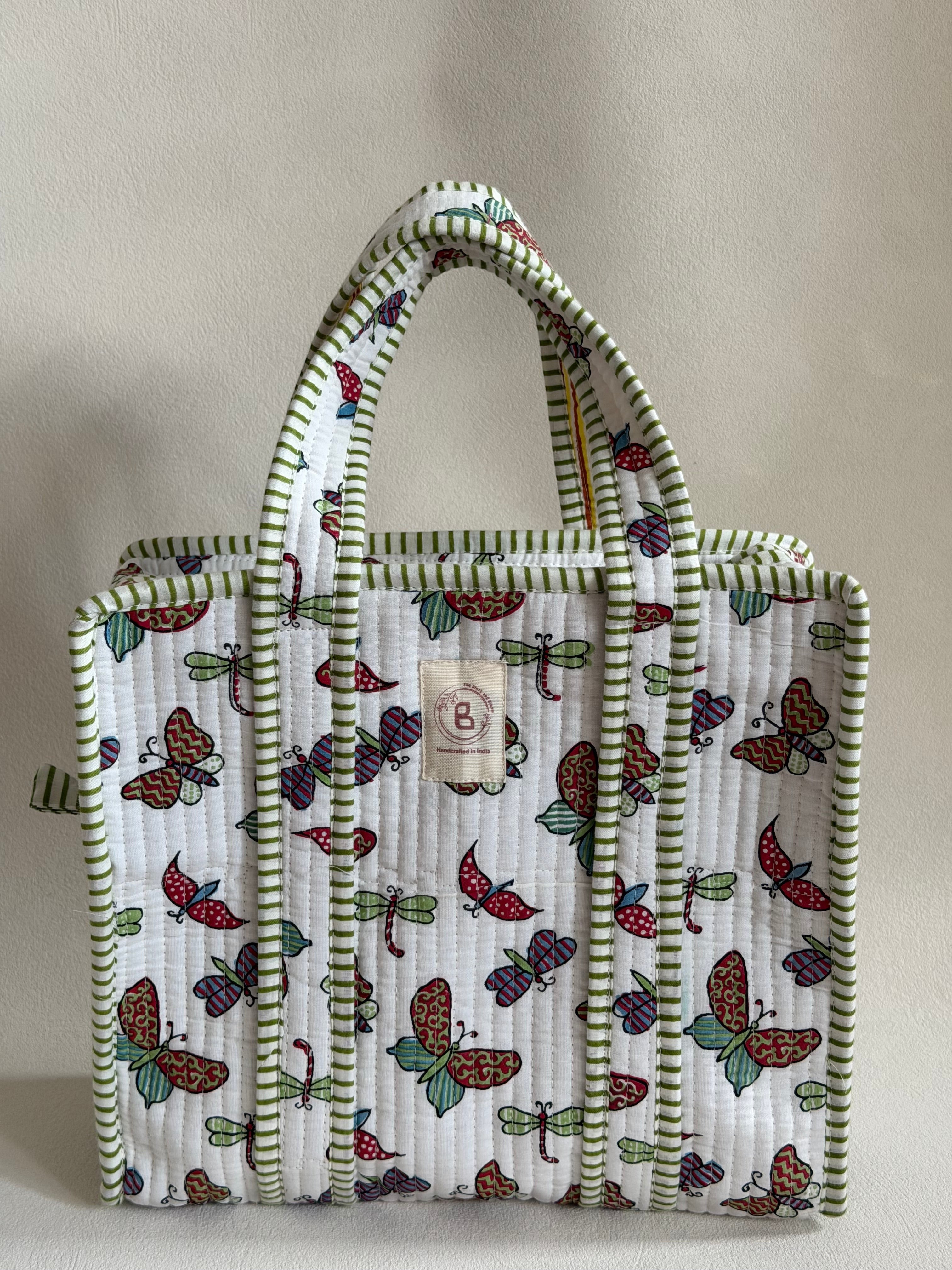 The Block & Bloom quilted mini tote featuring a white hand block-printed butterfly and dragonfly motif with green trim
