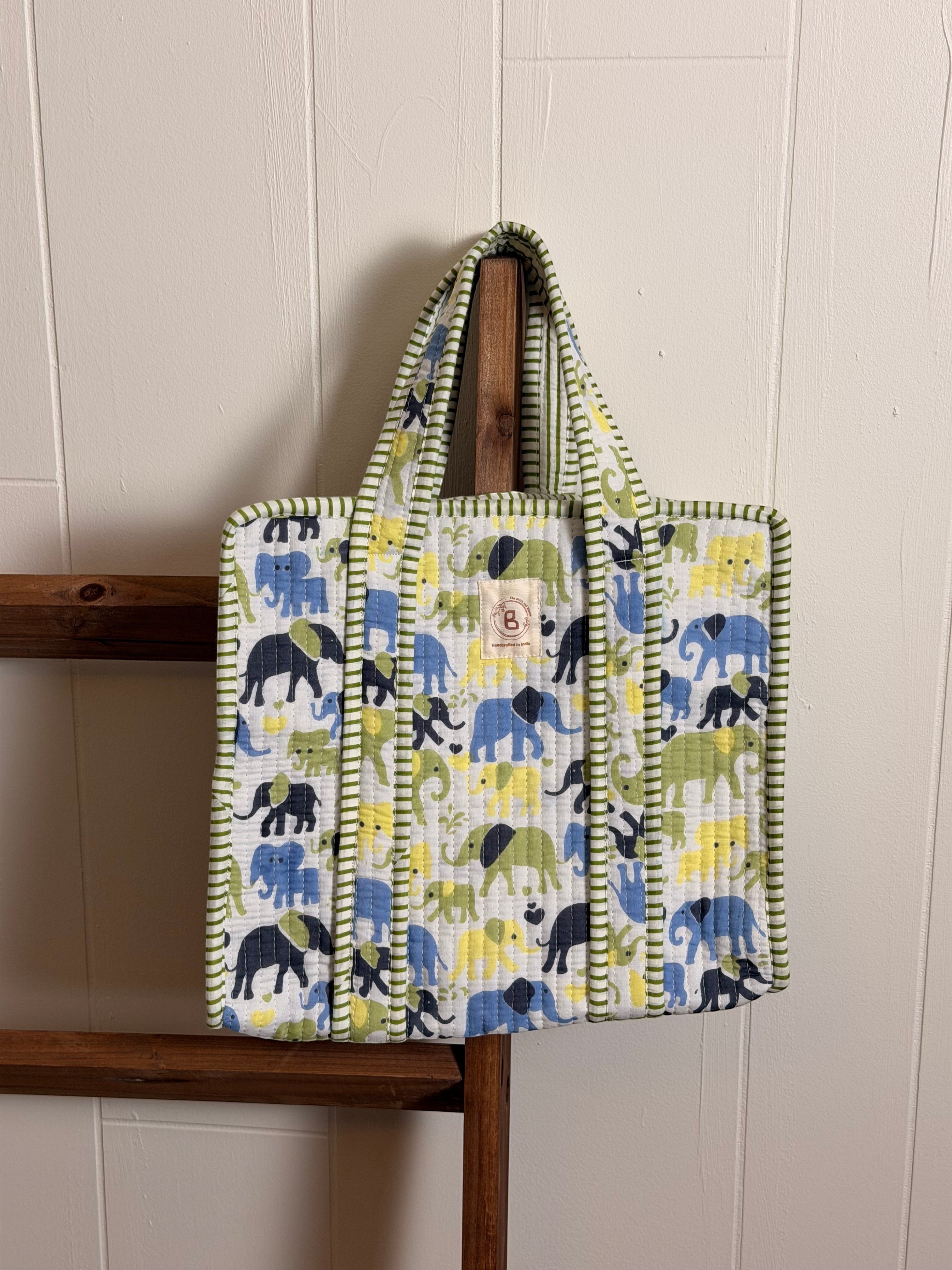 The Block & Bloom quilted mini tote featuring a hand block-printed elephant pattern in blue, yellow, and green.