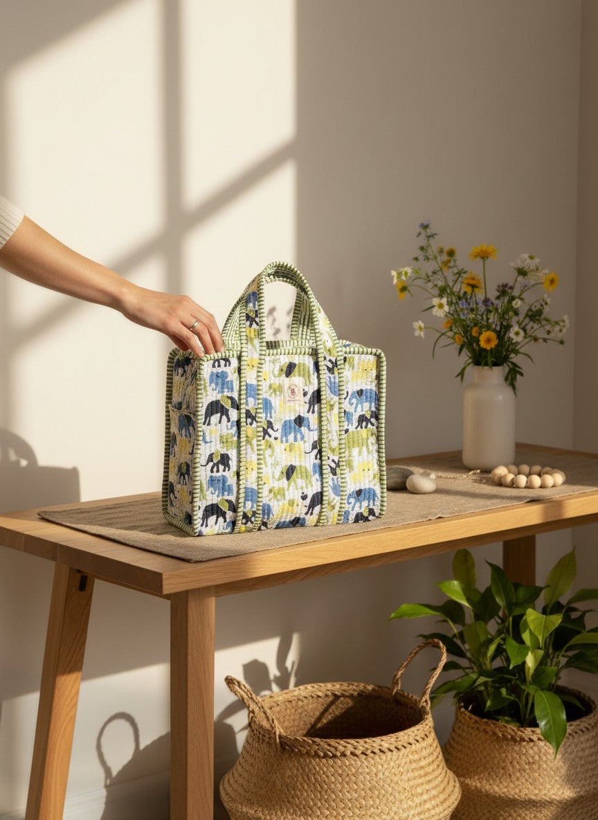The Block & Bloom quilted mini tote featuring a blue and yellow elephant print with green gingham trim on a table.