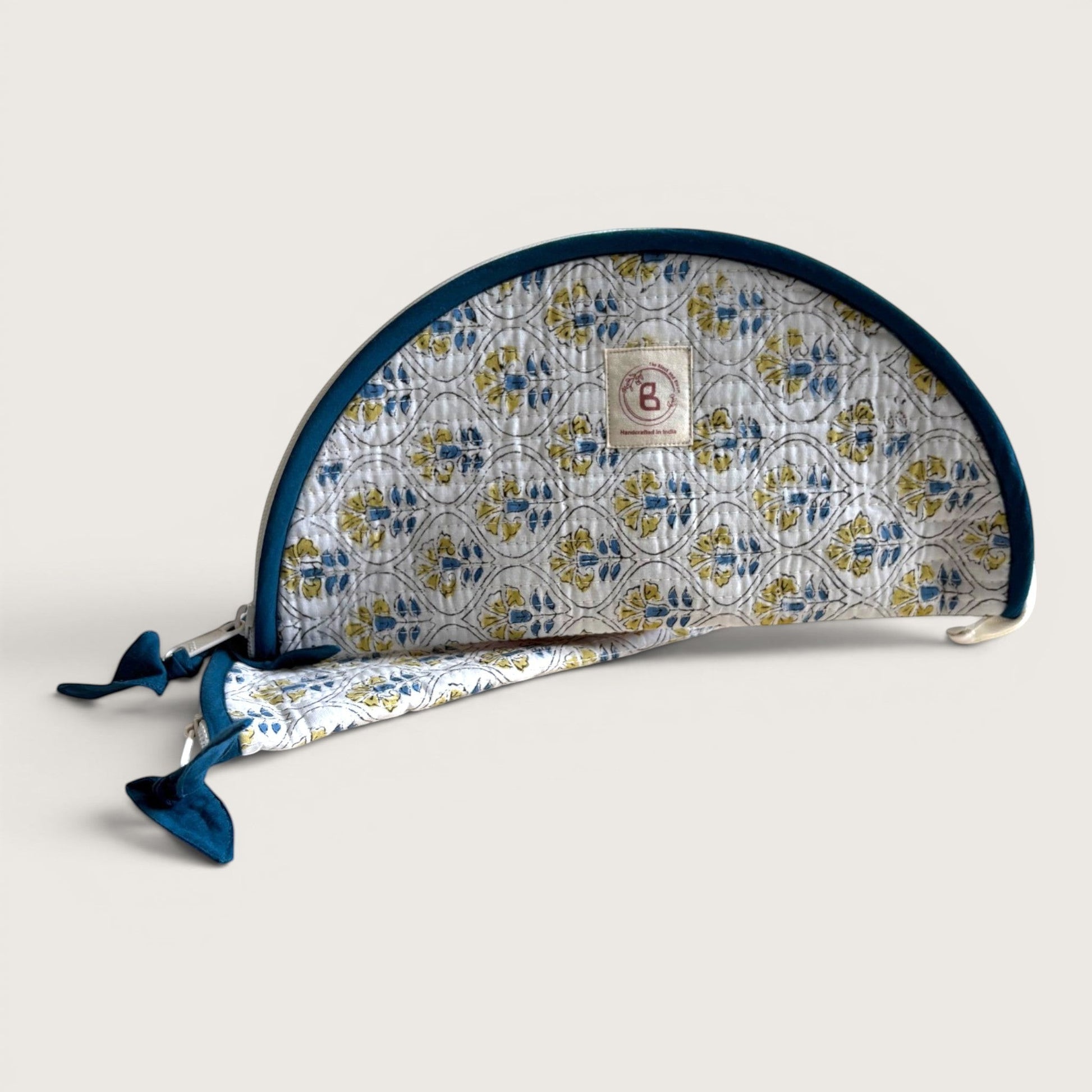 The Block & Bloom quilted cotton makeup brush pouch featuring a white, blue, and golden yellow floral tile pattern.
