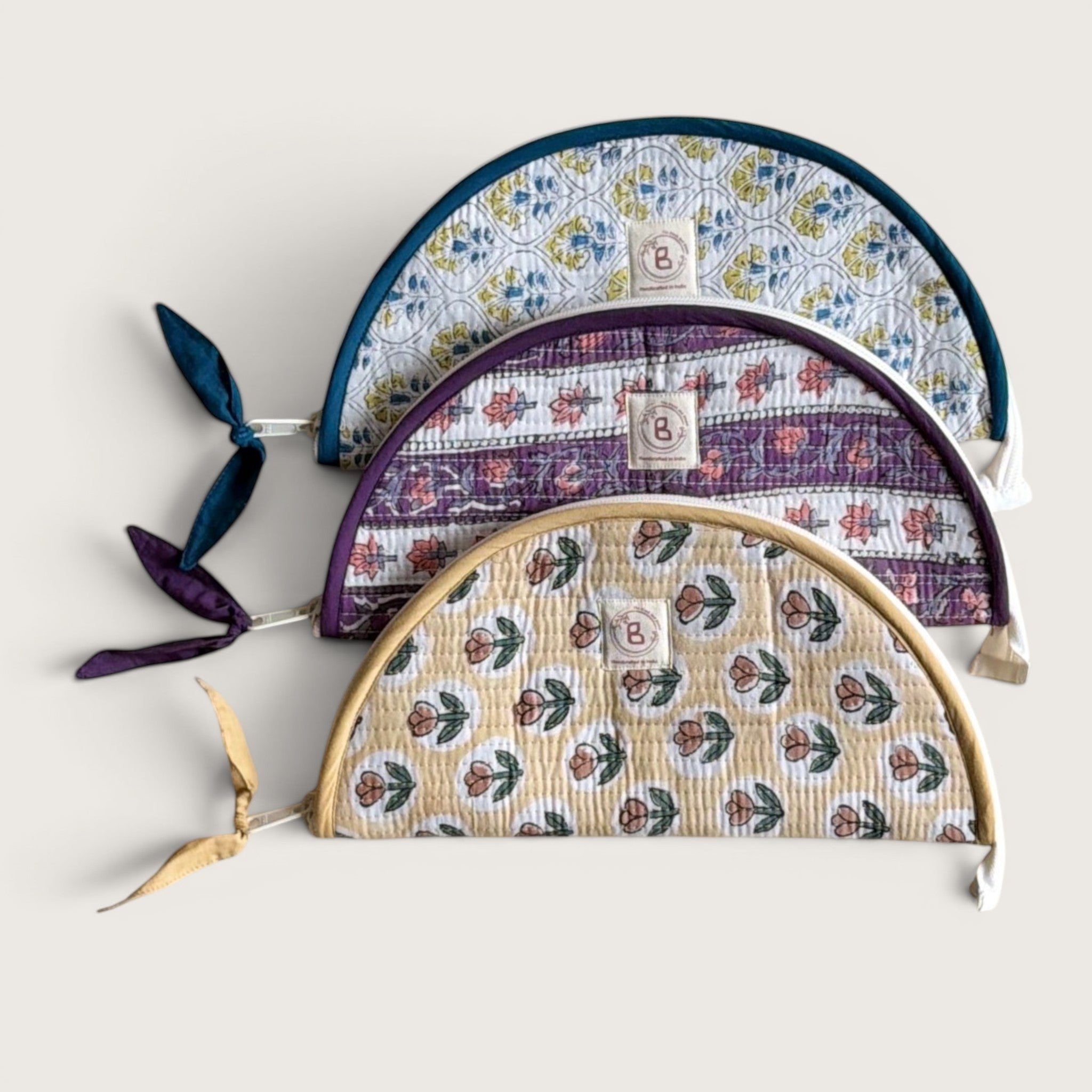 The Block & Bloom quilted makeup brush pouches in floral patterns with blue, purple, and yellow cotton designs.