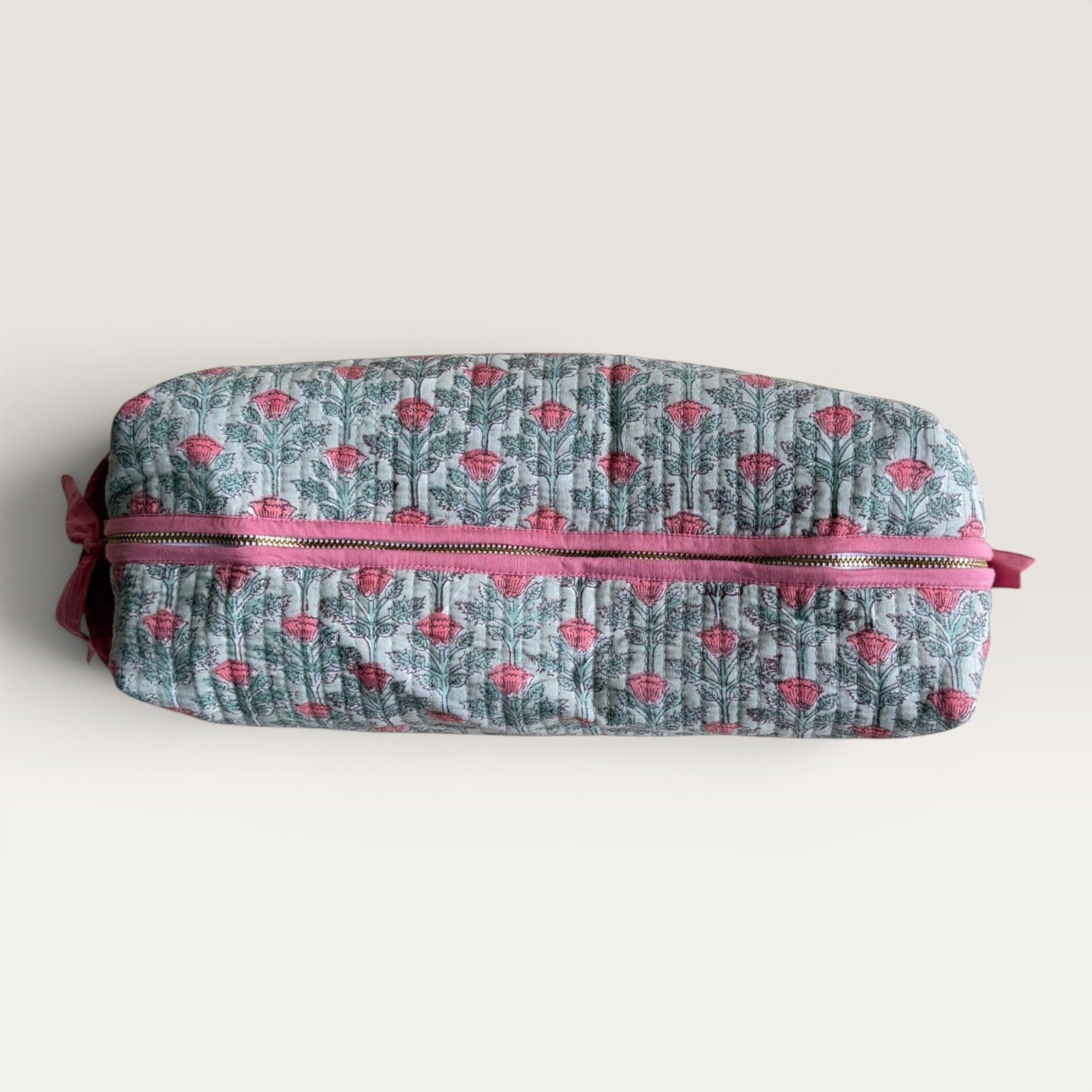 The Block & Bloom quilted hair tool organizer bag in sage green with a pink floral vine print and secure zipper closure.