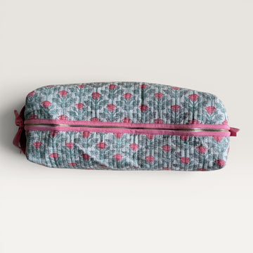 The Block & Bloom quilted hair tool organizer bag in sage green with a pink floral vine print and secure zipper closure.