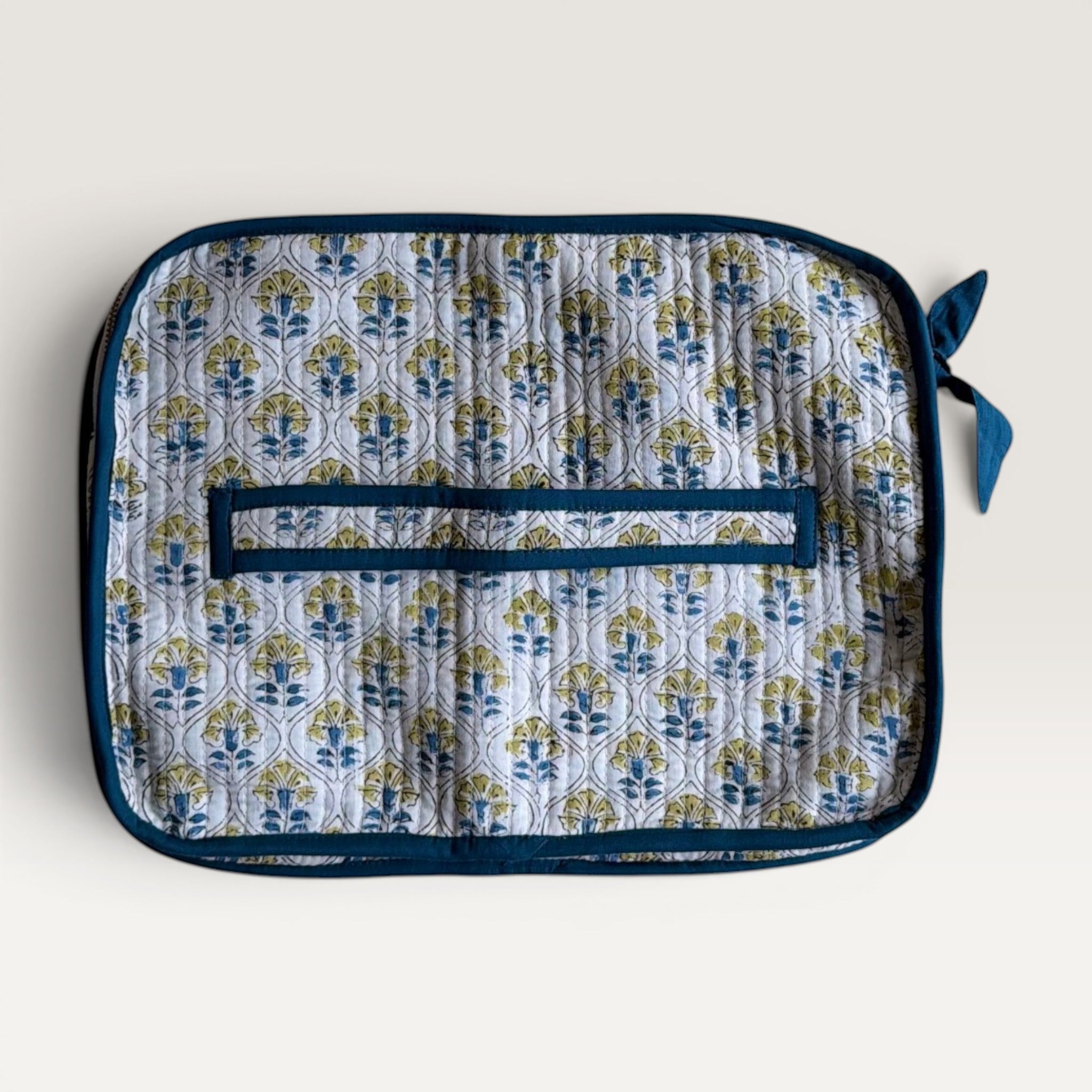 The Block & Bloom quilted laptop sleeve in white with blue and yellow cosmos floral tile print and back hand strap.
