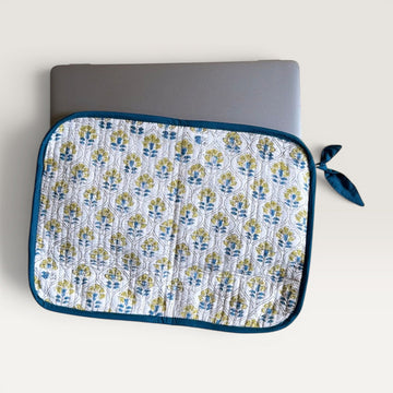The Block & Bloom quilted laptop sleeve featuring a blue and yellow floral tile pattern on white with a fabric bow.