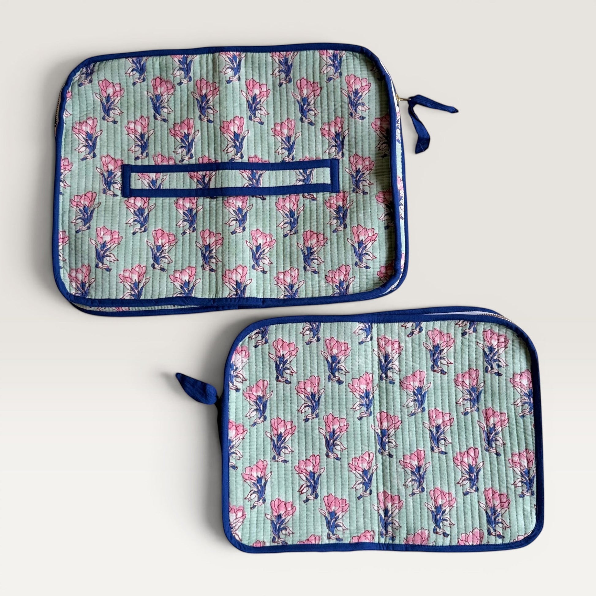 The Block & Bloom quilted laptop sleeve in sage green with pink saffron floral print and navy blue trim.