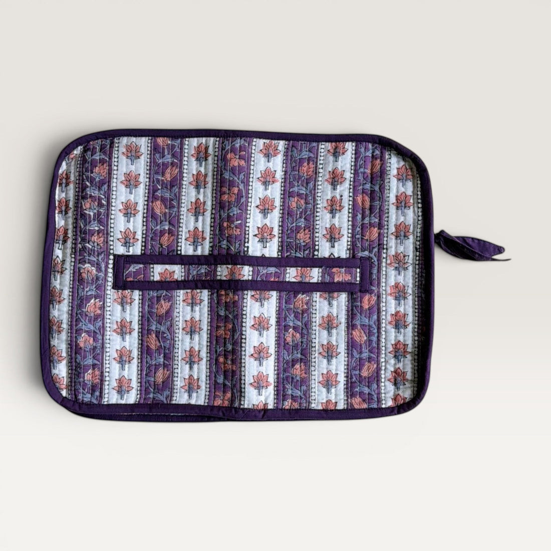 The Block & Bloom quilted laptop sleeve in lavender and ivory with hand block-printed floral vine patterns and a bow.