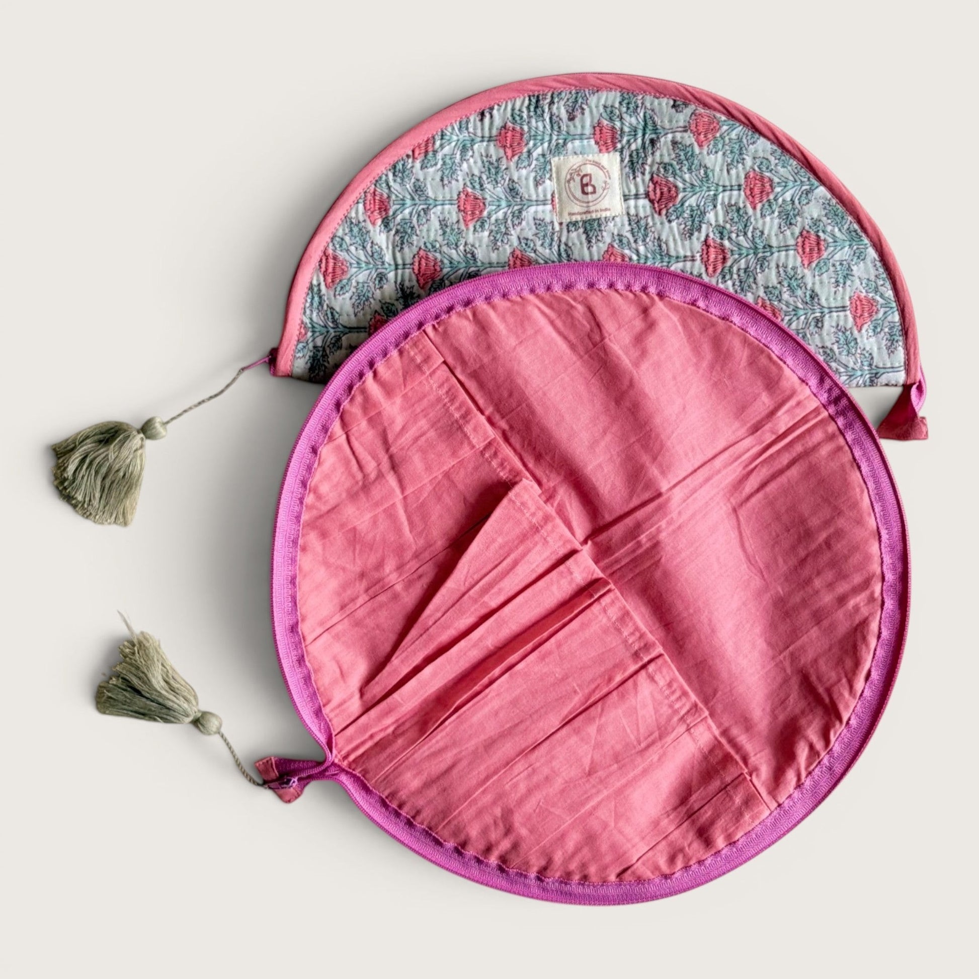 The Block & Bloom quilted makeup brush pouch in sage green with pink floral print and a solid pink interior with slots.
