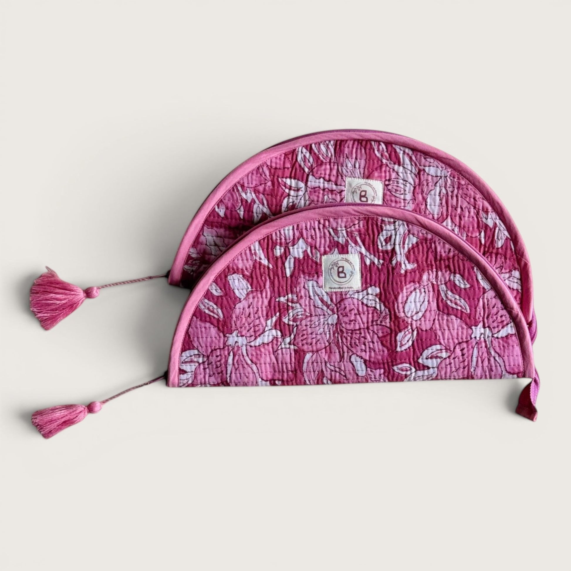 The Block & Bloom quilted makeup brush pouch in pink and white floral cotton with tassel zipper pulls.