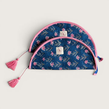 The Block & Bloom quilted makeup brush pouch in navy blue with pink carnation floral print and pink tassel zippers.