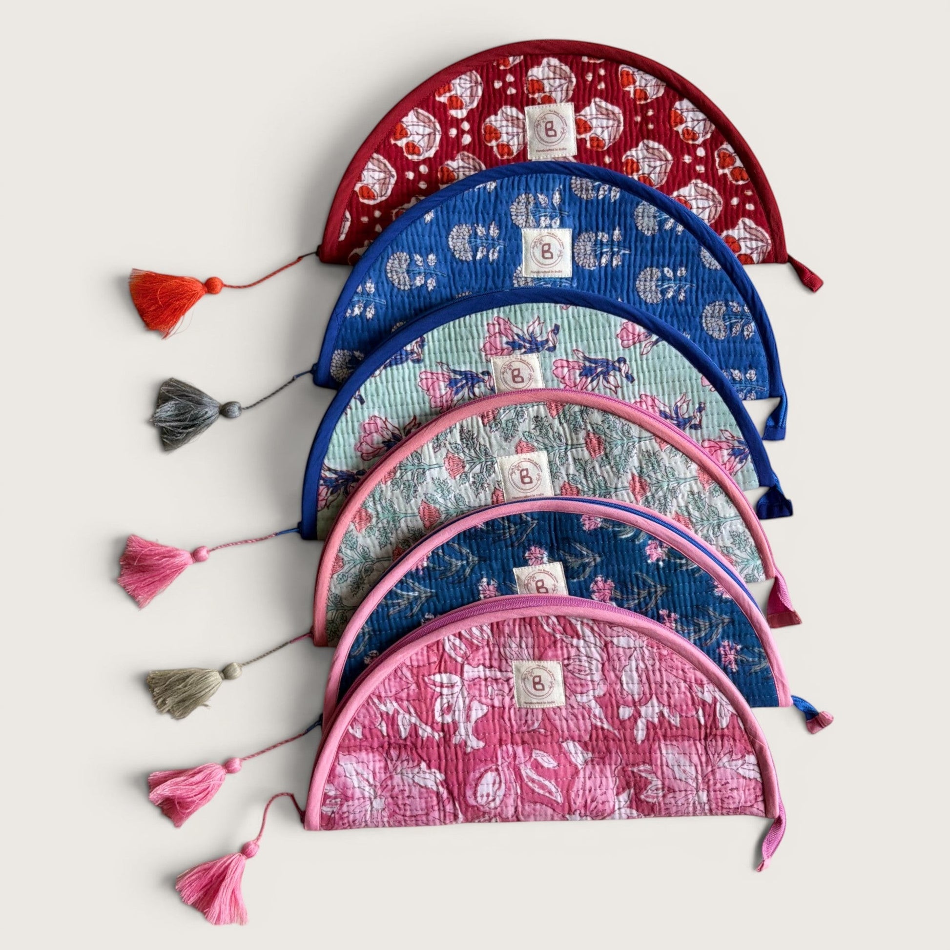 The Block & Bloom quilted makeup brush pouches in various floral patterns and colors with tassel zipper pulls.