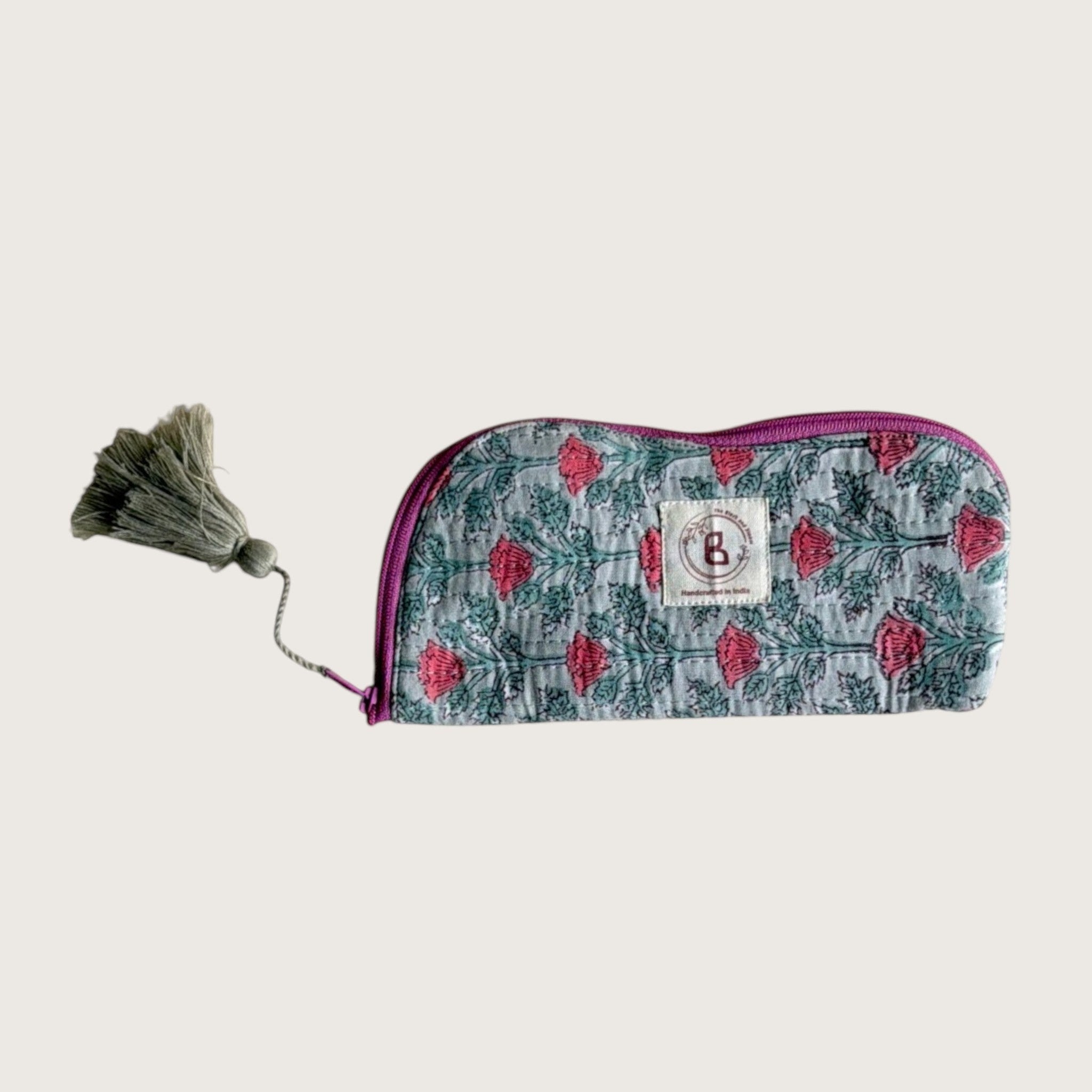 The Block & Bloom quilted cotton sunglasses pouch in sage green with pink floral vine print and a decorative tassel.