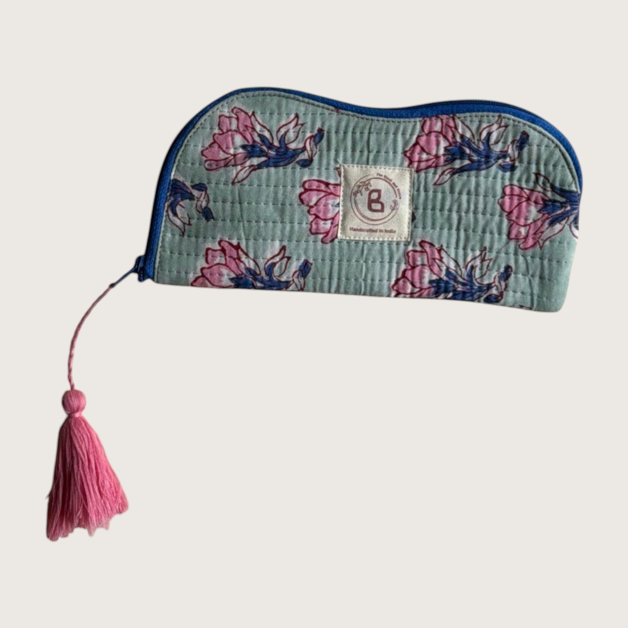 The Block & Bloom quilted cotton sunglasses pouch in sage green with pink floral print and a decorative pink tassel.