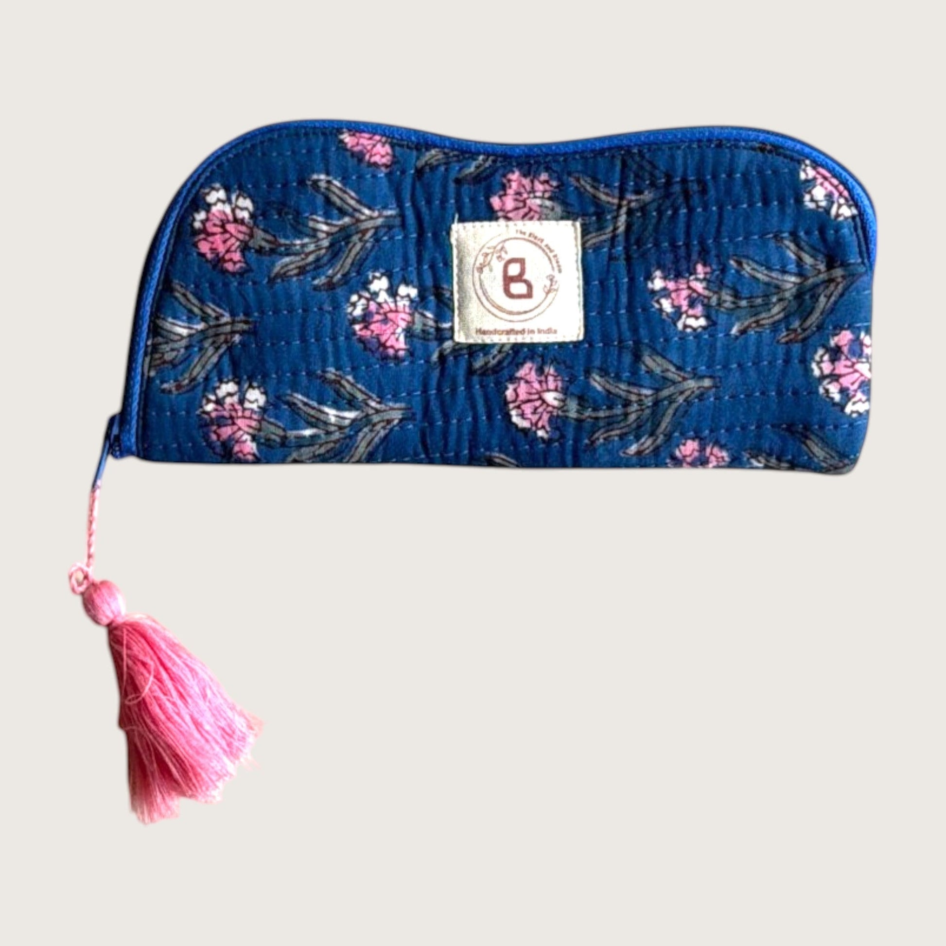 The Block & Bloom quilted cotton sunglasses pouch in navy blue with pink carnation floral print and pink tassel.