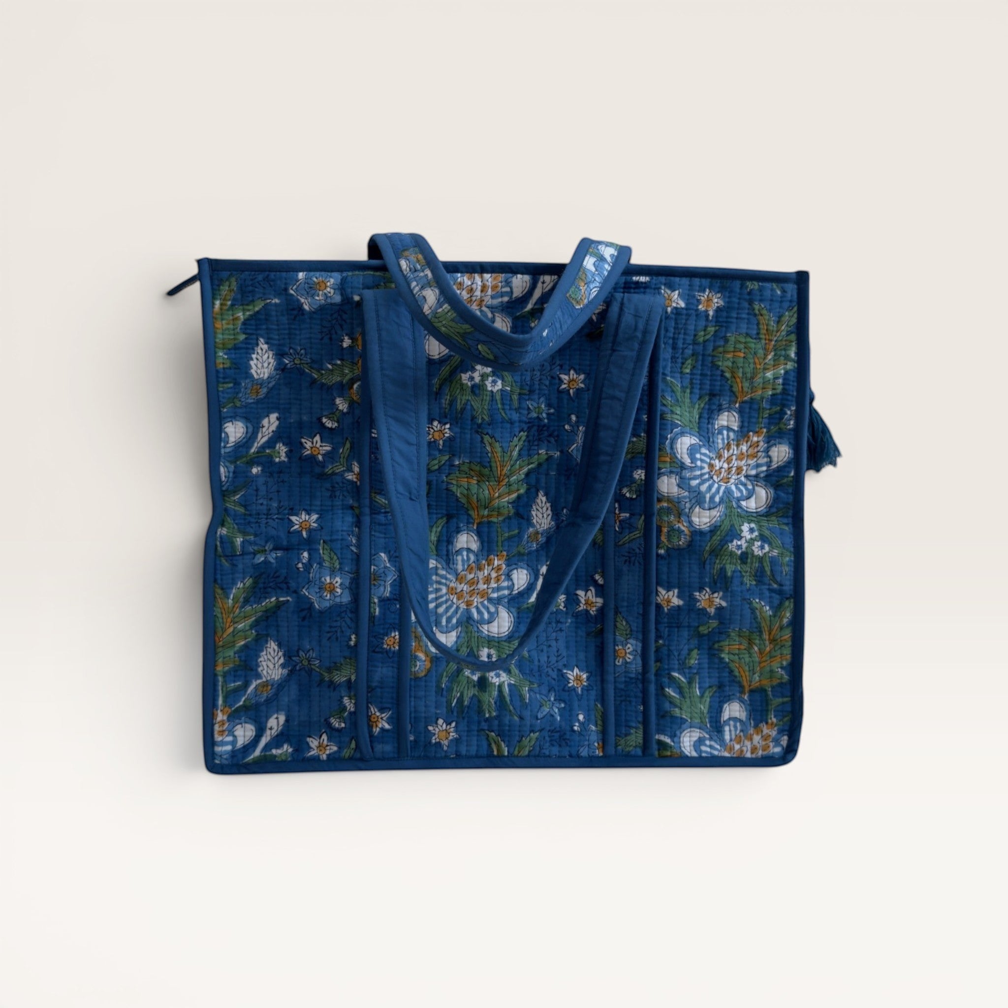 The Block & Bloom quilted tote bag in cobalt blue with white gardenia floral block print and structured base.