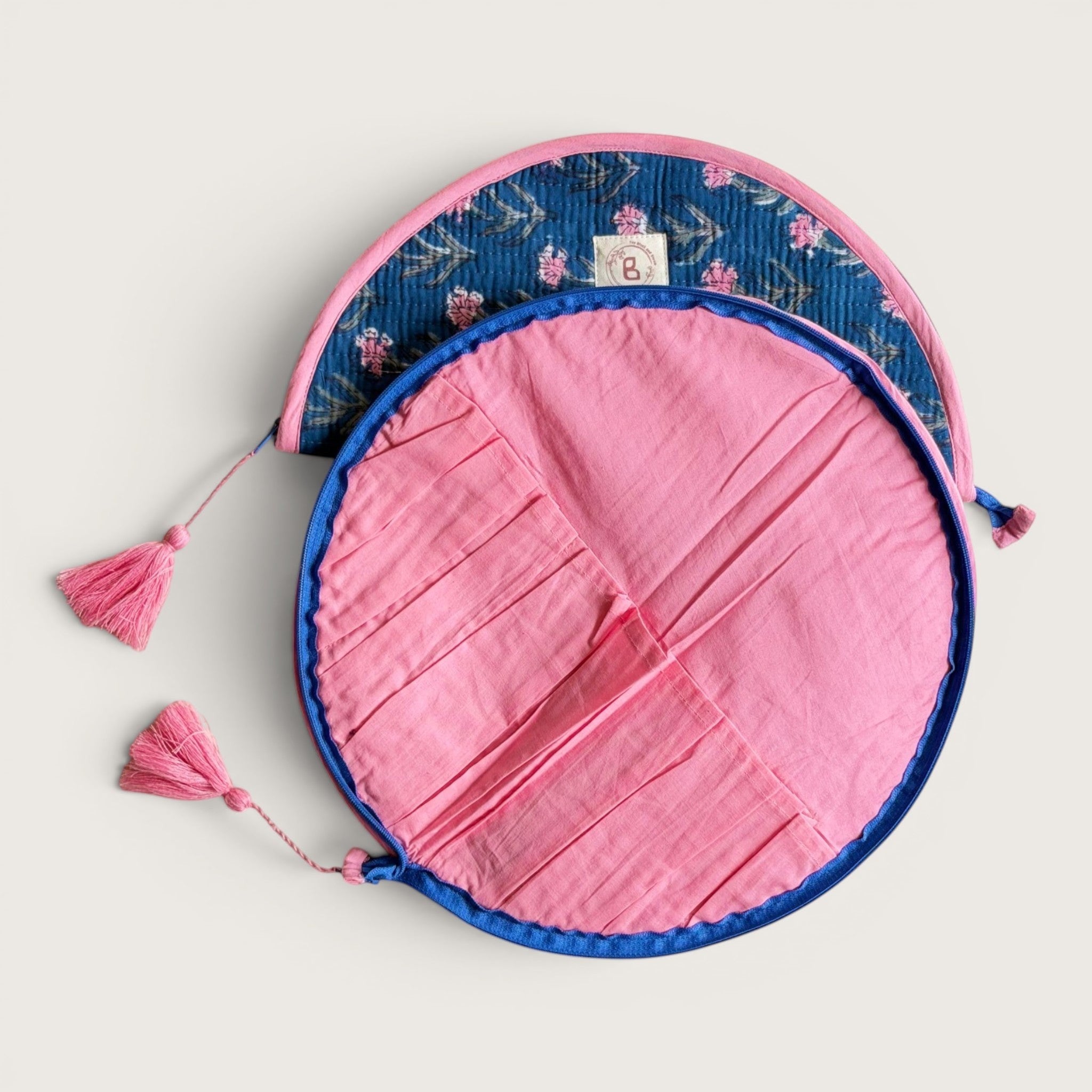 The Block & Bloom quilted makeup brush pouch in navy blue with pink carnations and a solid pink interior with slots.
