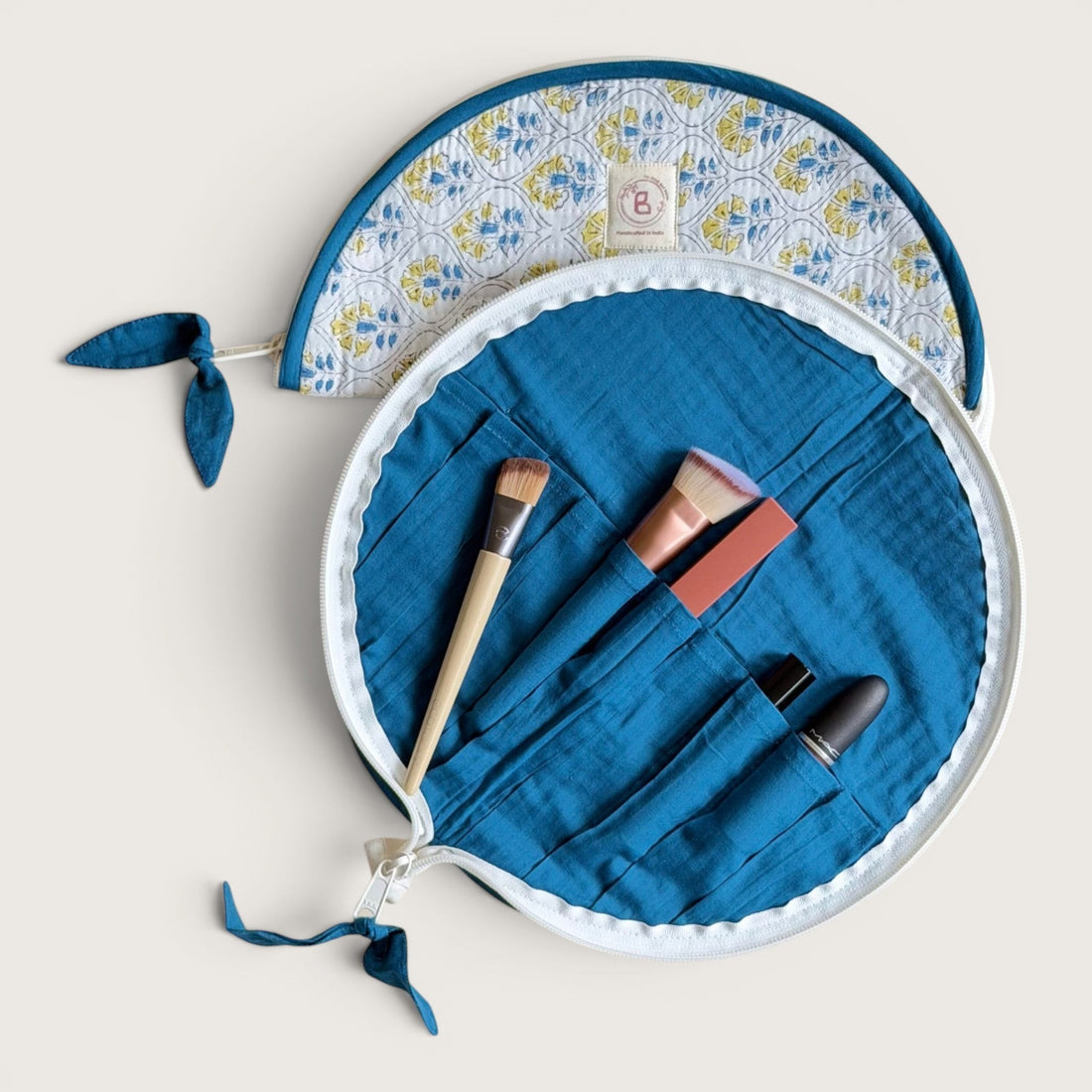The Block & Bloom Cosmos Tile quilted cotton makeup brush pouch with blue and yellow floral lattice print.