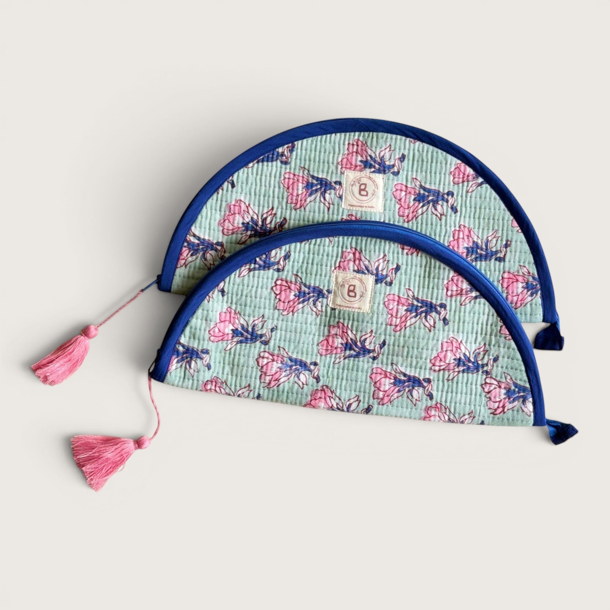 The Block & Bloom quilted makeup brush pouch in sage green with pink saffron flower print and navy blue trim.