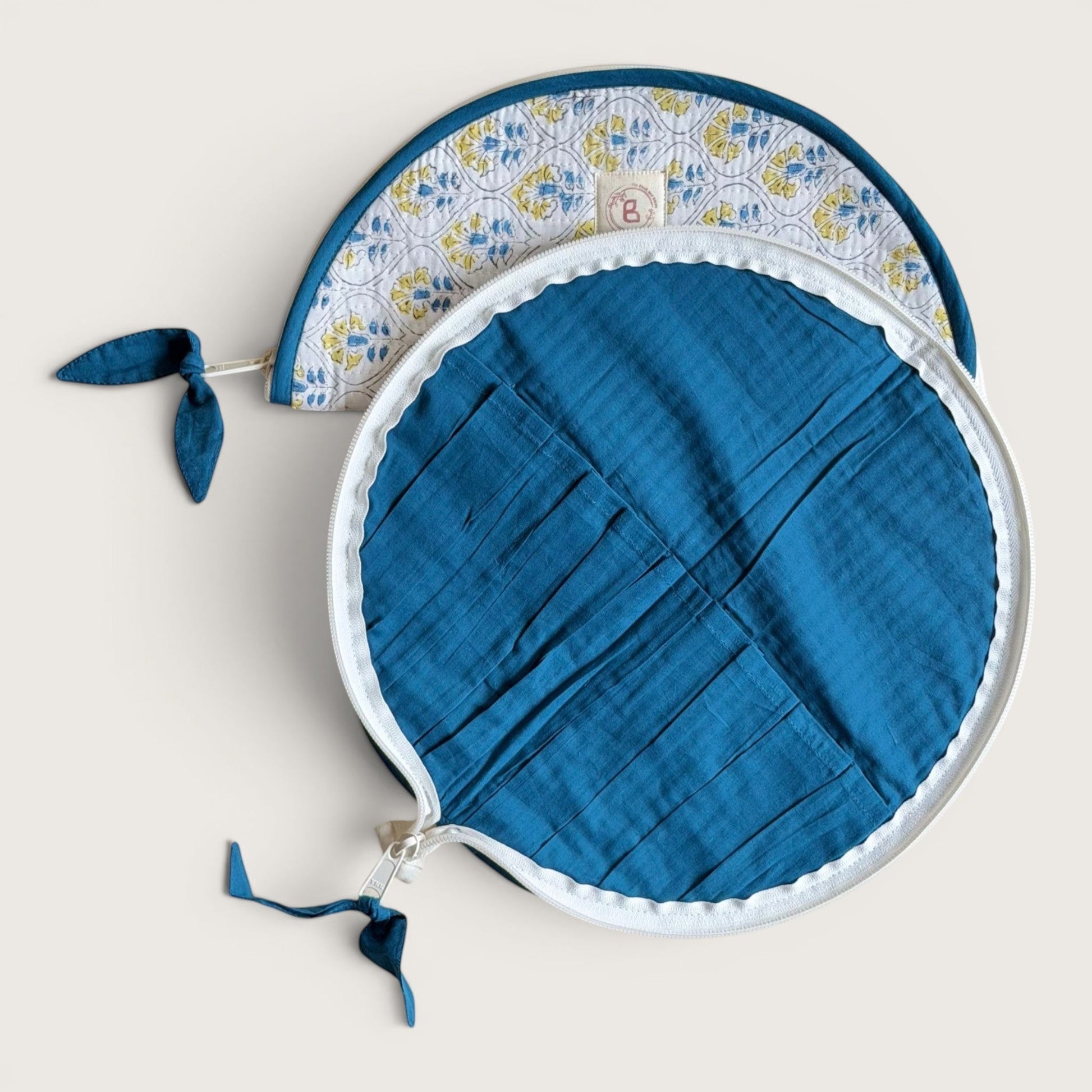 The Block & Bloom Cosmos Tile quilted makeup brush pouch with blue interior slots and floral white exterior.