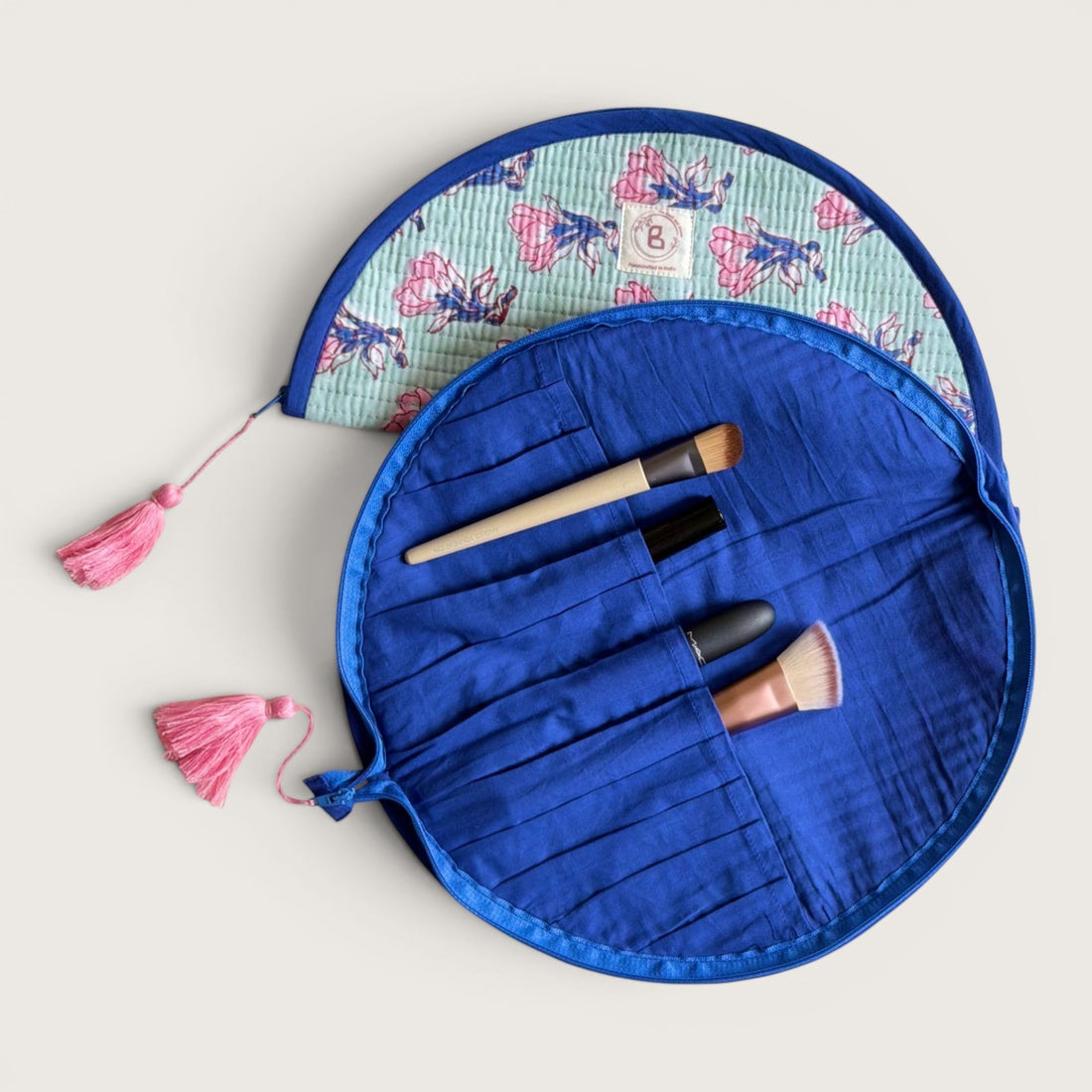 The Block & Bloom quilted makeup brush pouch in sage green with pink saffron flower print and navy blue trim.