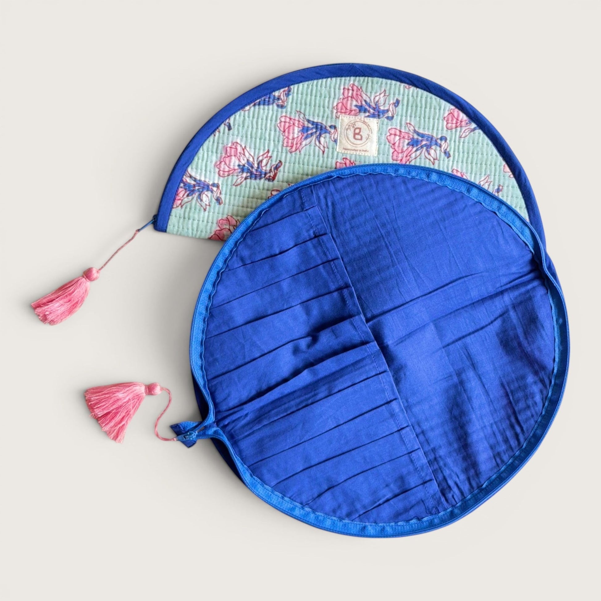 The Block & Bloom quilted makeup brush pouch in sage green with pink floral print and navy blue interior slots.