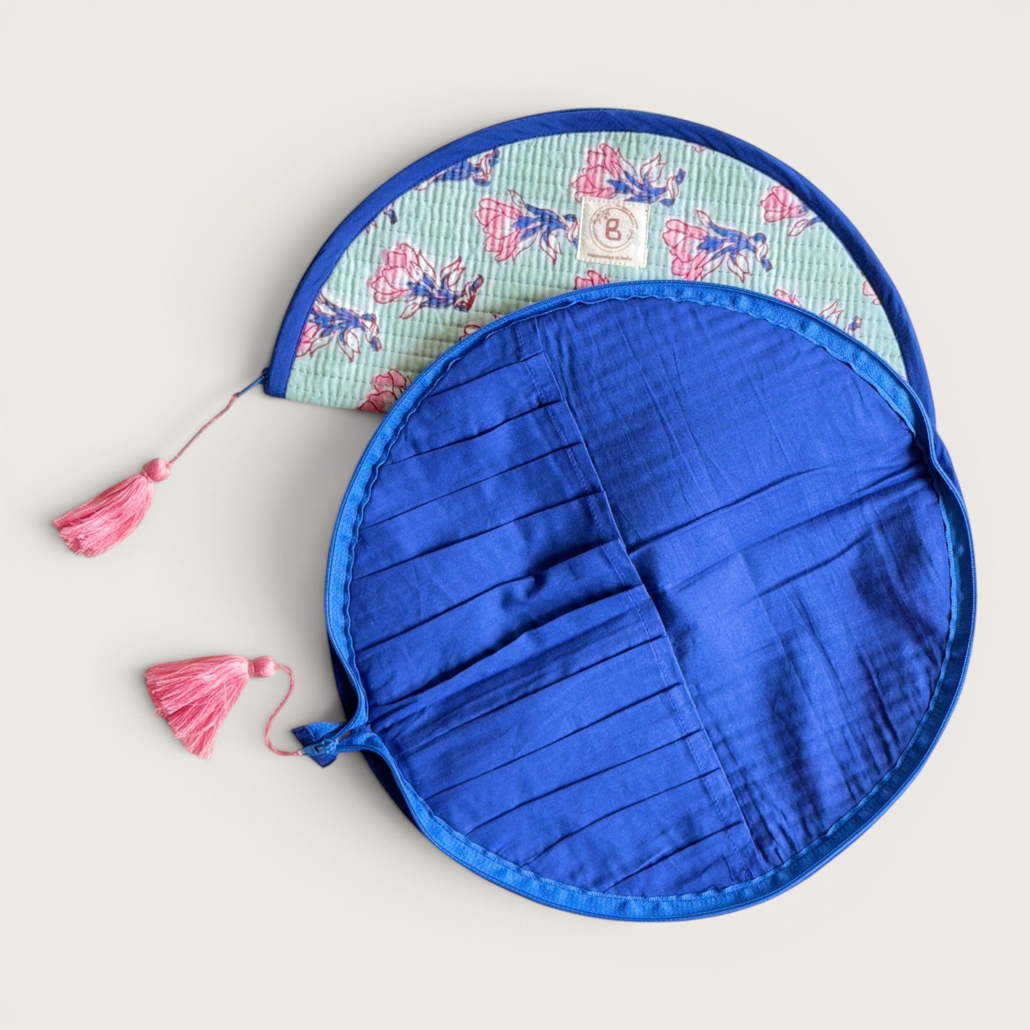 The Block & Bloom quilted makeup brush pouch in sage green with pink floral print and navy blue interior slots.