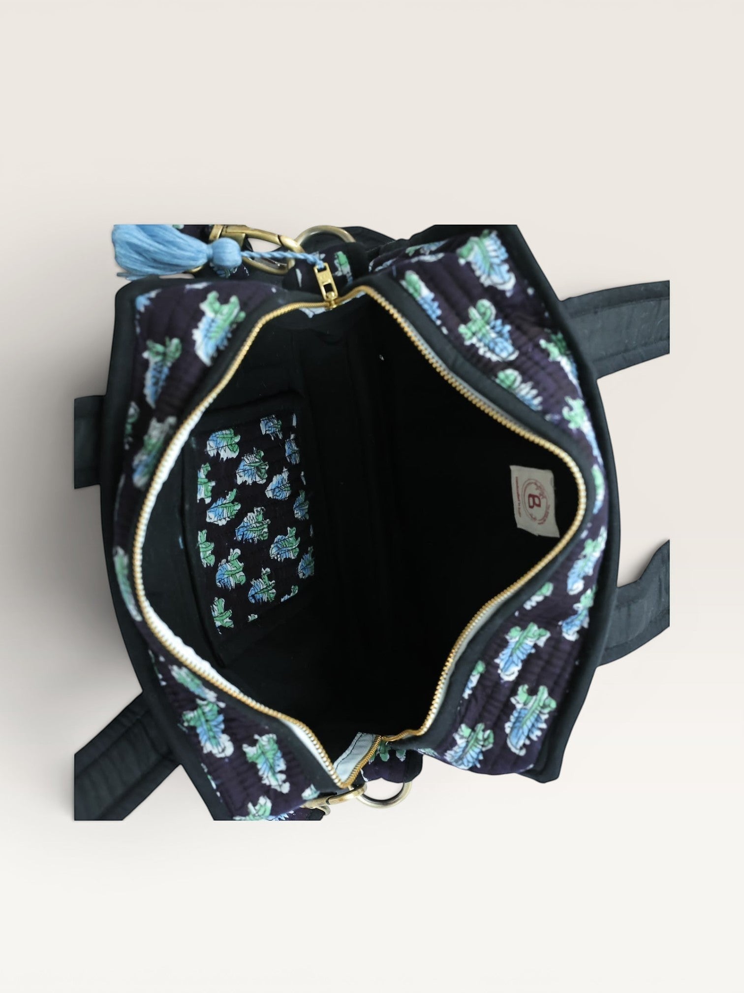 The Block & Bloom Midnight Fern quilted mini tote bag interior with blue and sage leaf print and brass hardware.