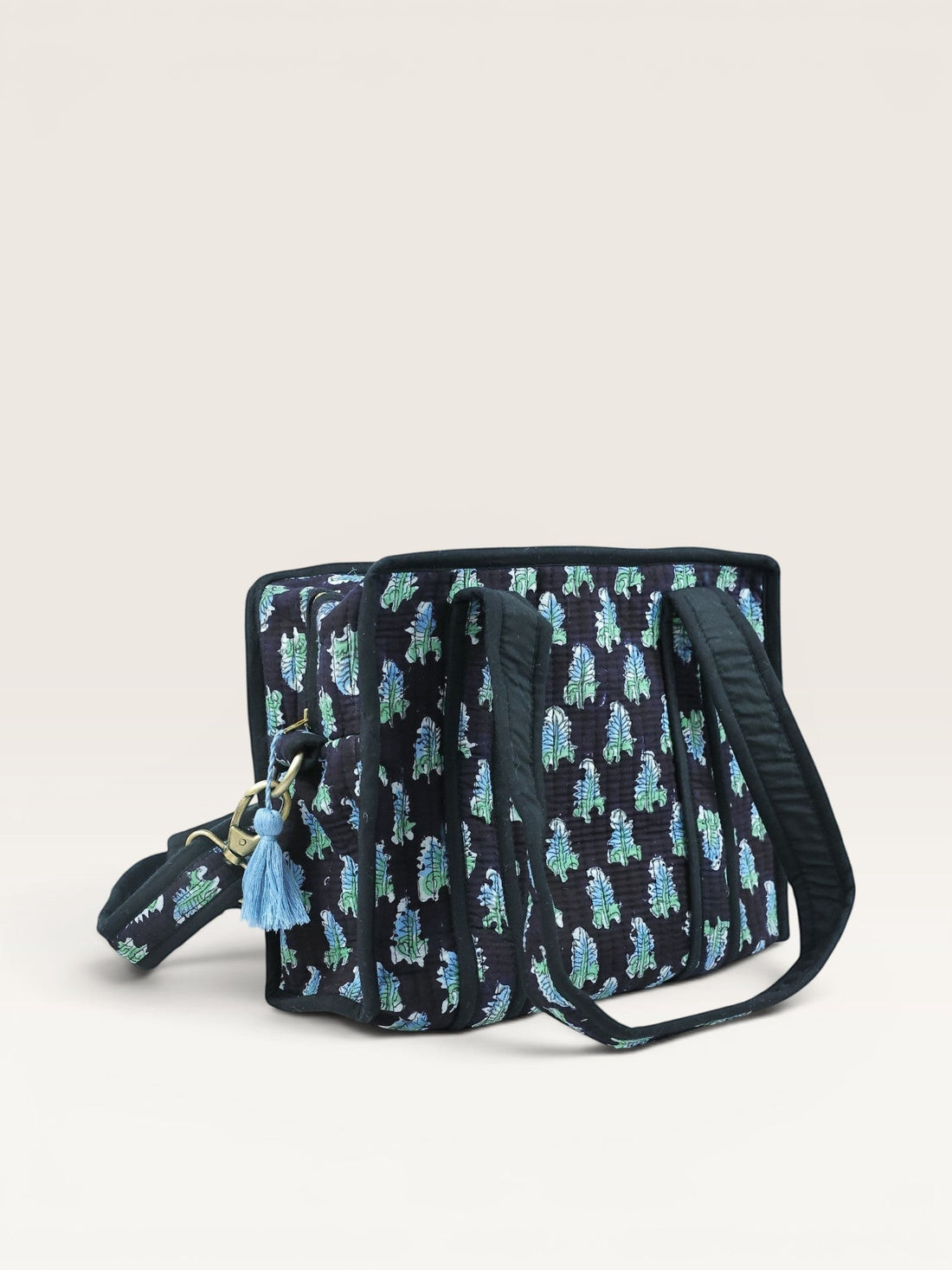The Block & Bloom Midnight Fern quilted mini tote bag in black with blue and sage green leaf print and brass hardware.
