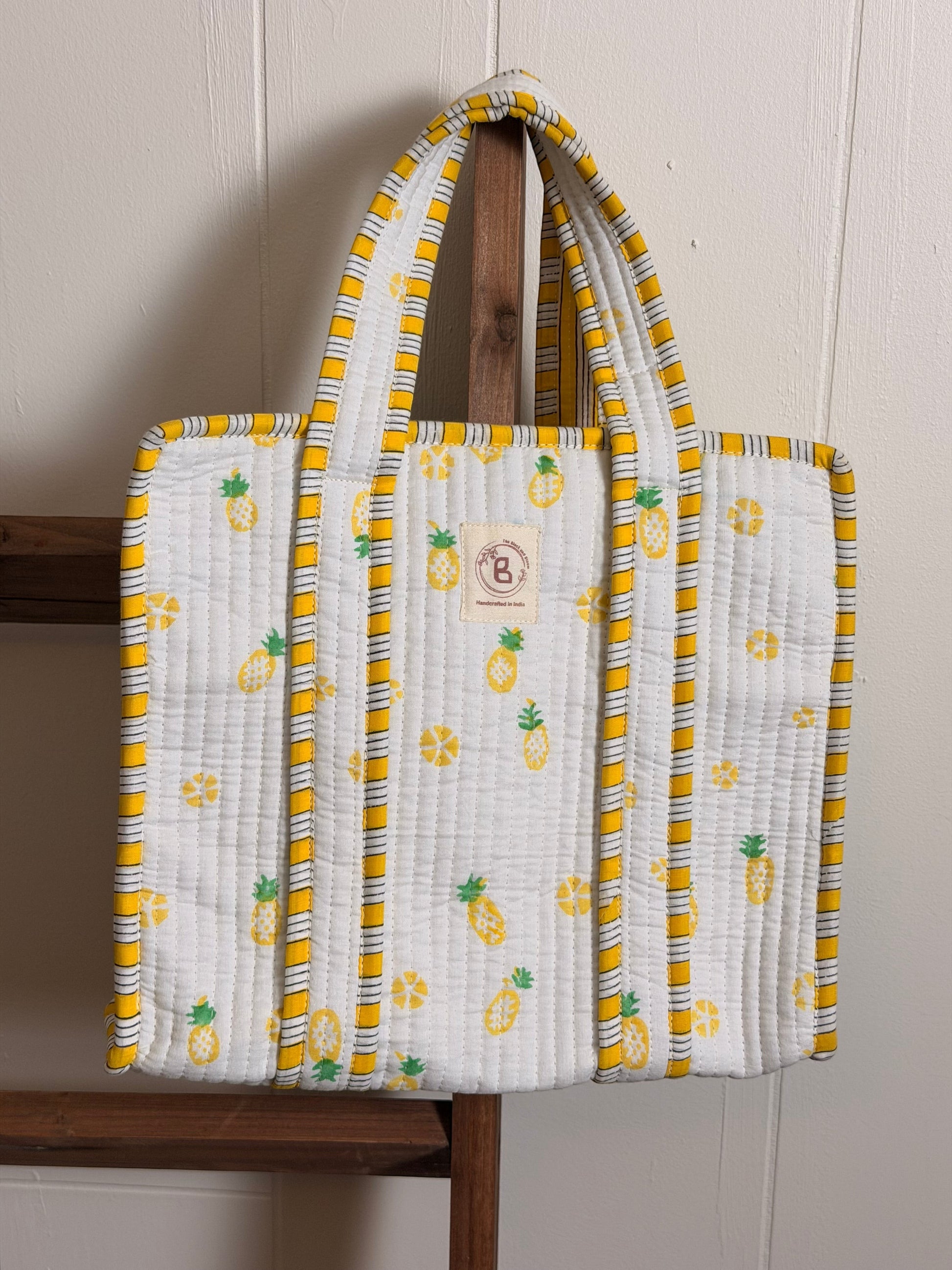 The Block & Bloom quilted mini tote with yellow and green pineapple print on white cotton with striped trim.