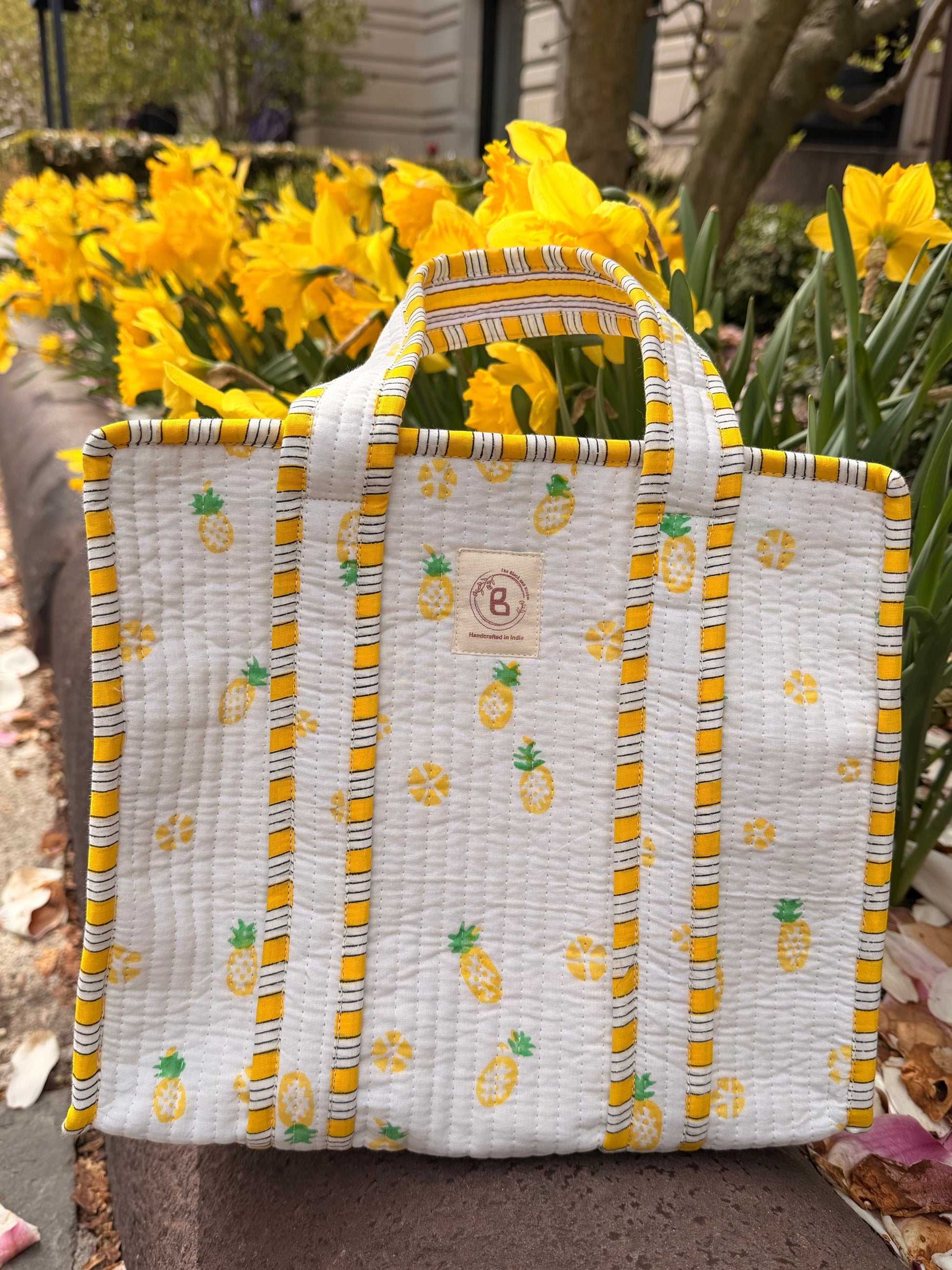 The Block & Bloom quilted mini tote featuring a yellow pineapple print on white cotton with yellow striped trim.