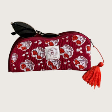 The Block & Bloom quilted sunglasses pouch in burgundy red with red tulip motifs, featuring a red tassel zipper pull.