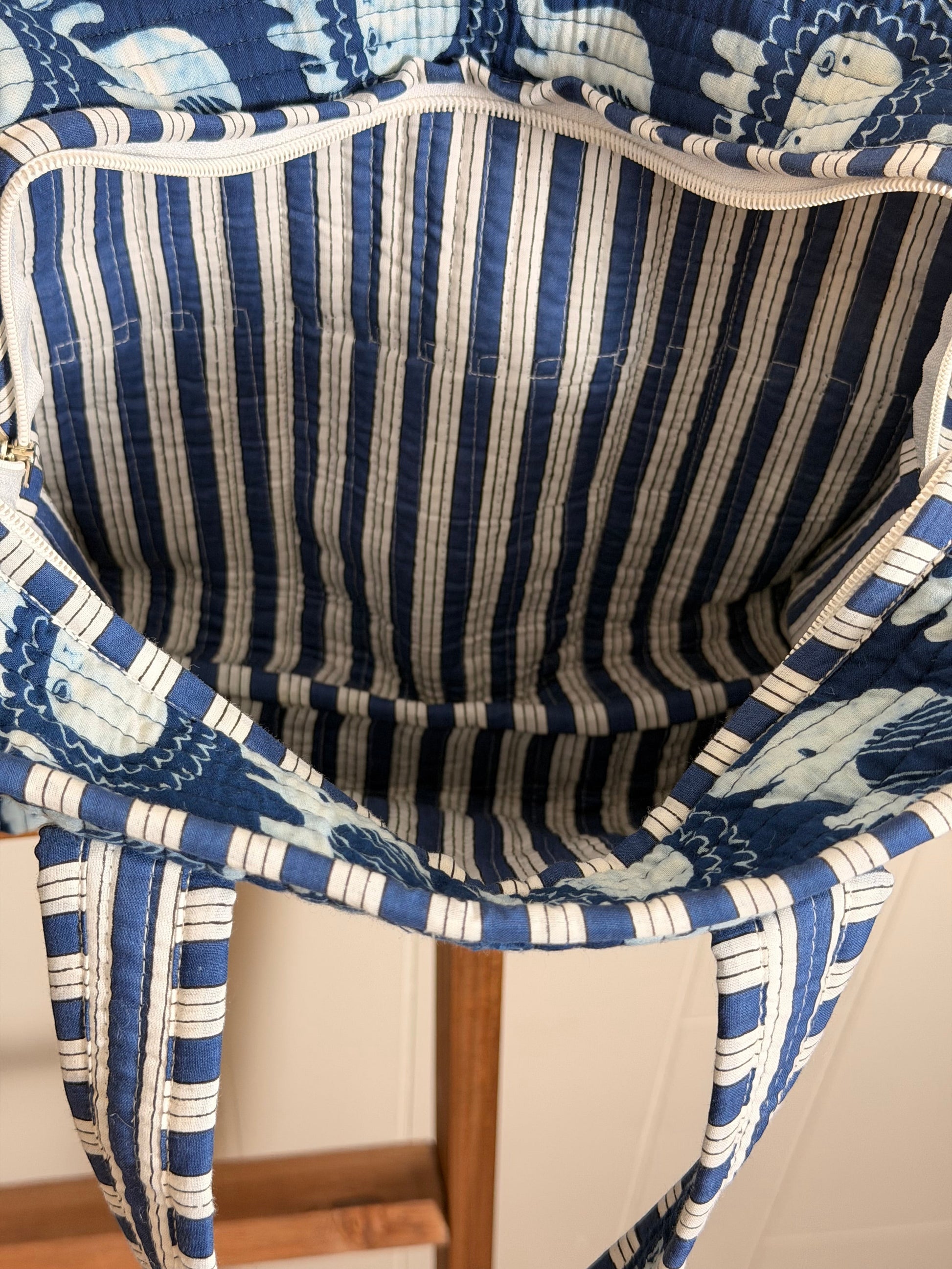 The Block & Bloom Ella & Leo quilted mini tote interior featuring blue and white striped lining and zipper closure.