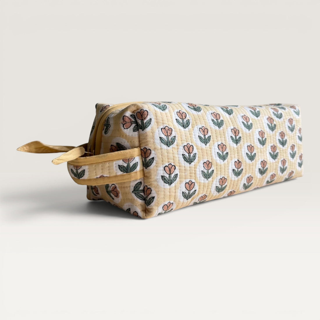 The Block & Bloom quilted hair tool organizer bag in golden yellow with a rust brown tulip block-print pattern.